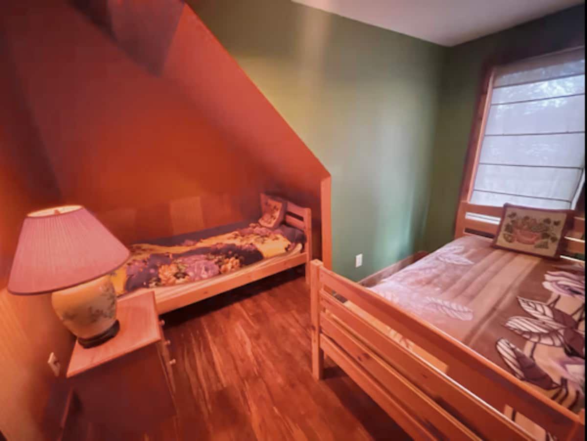 Cozy twin bedroom with warm wood accents and charming alcove bed