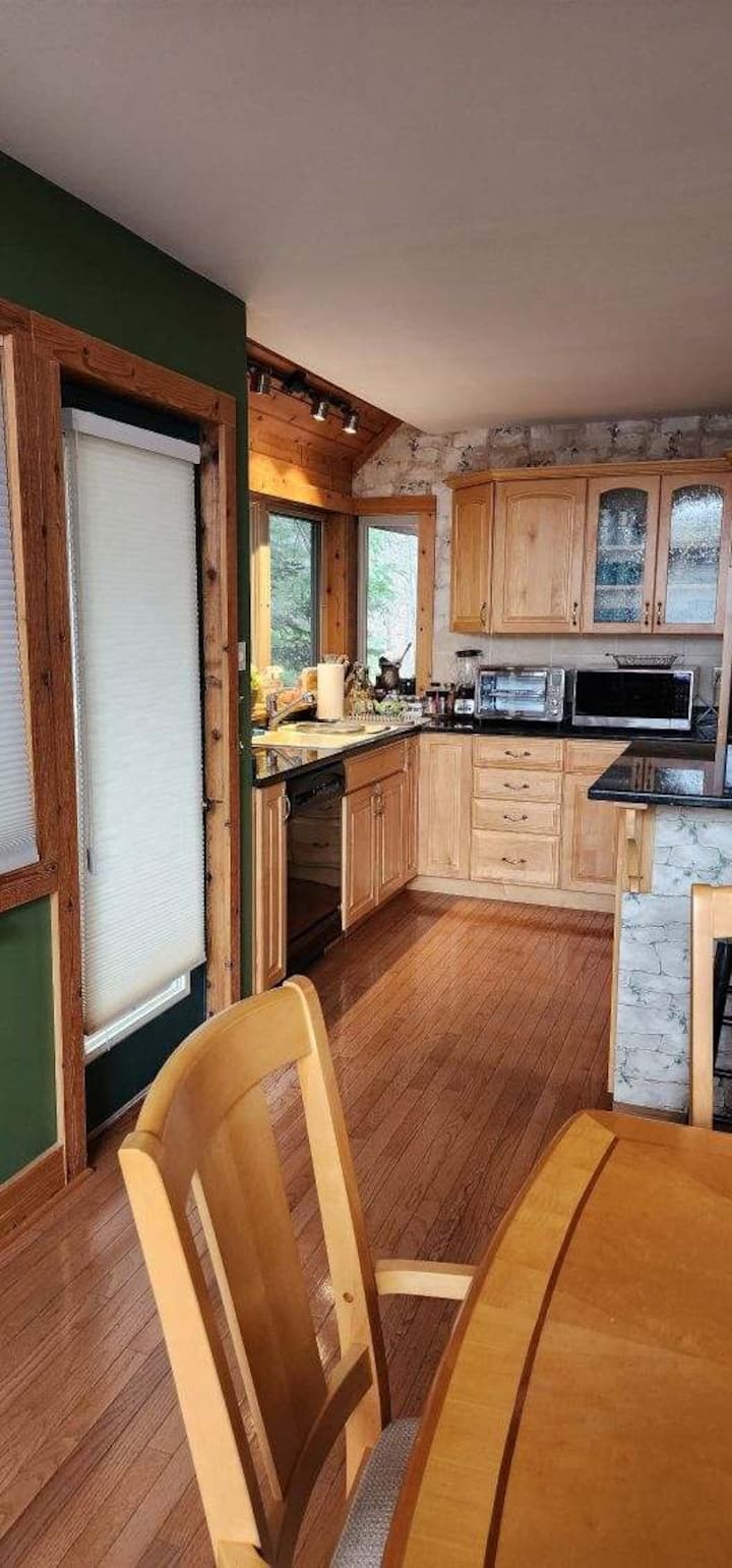 Cozy wood-accented kitchen with bright windows and inviting dining space