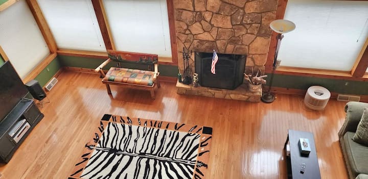 Bright A-frame living room with stone fireplace and warm cabin charm
