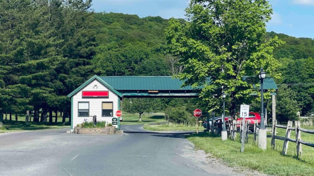 Scenic gated entrance surrounded by trees and rolling green hills