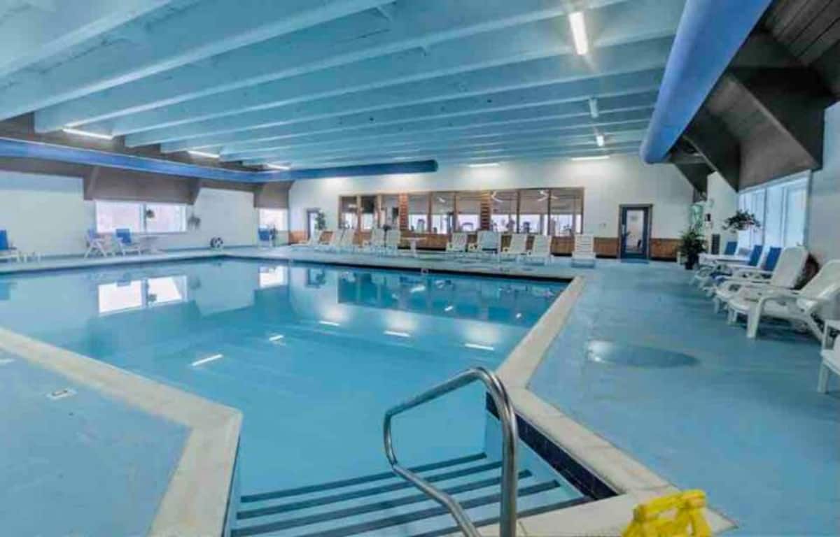 Spacious indoor pool with lounge seating for year-round guest enjoyment