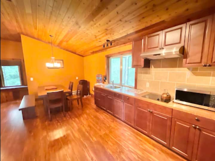 Warm wood kitchen with dining space and abundant natural light