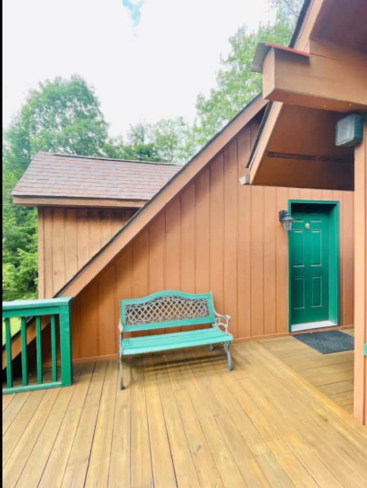 Welcoming cabin entry with spacious deck and peaceful wooded charm
