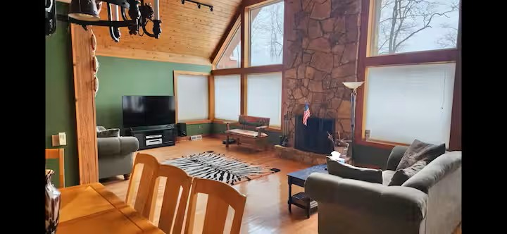 Vaulted ceilings, stone fireplace, and bright lodge-style living room