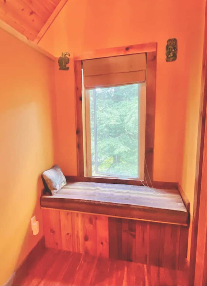Cozy window seat with wooded views—perfect for reading and relaxing