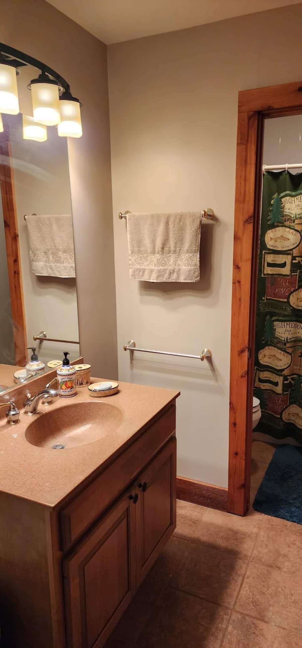 Warm rustic bathroom with bright vanity and separate shower/toilet area