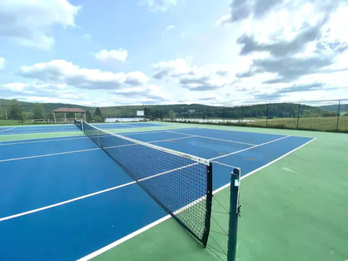 Scenic outdoor tennis courts with sweeping hilltop views