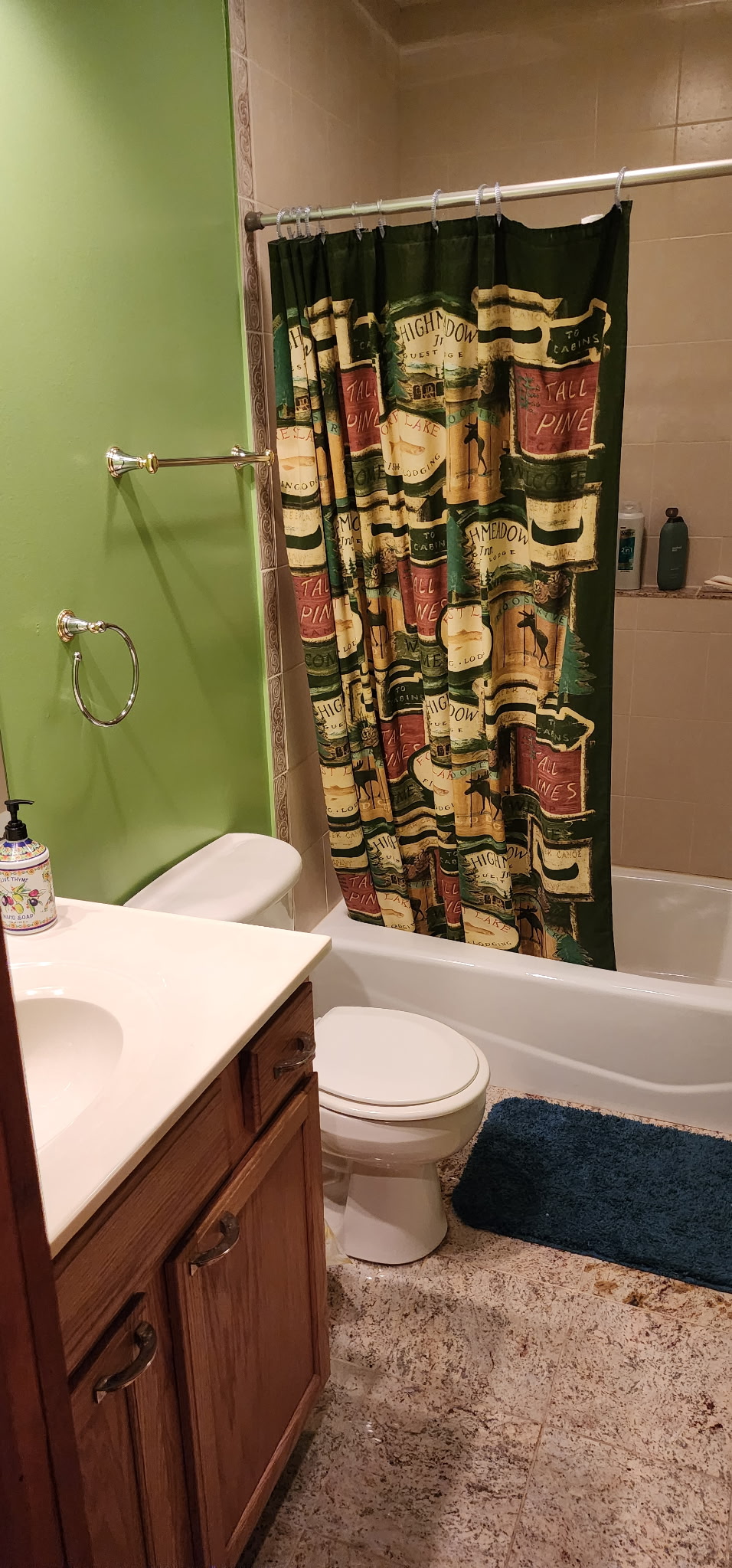 Cozy full bathroom with tub-shower combo and warm, homey finishes