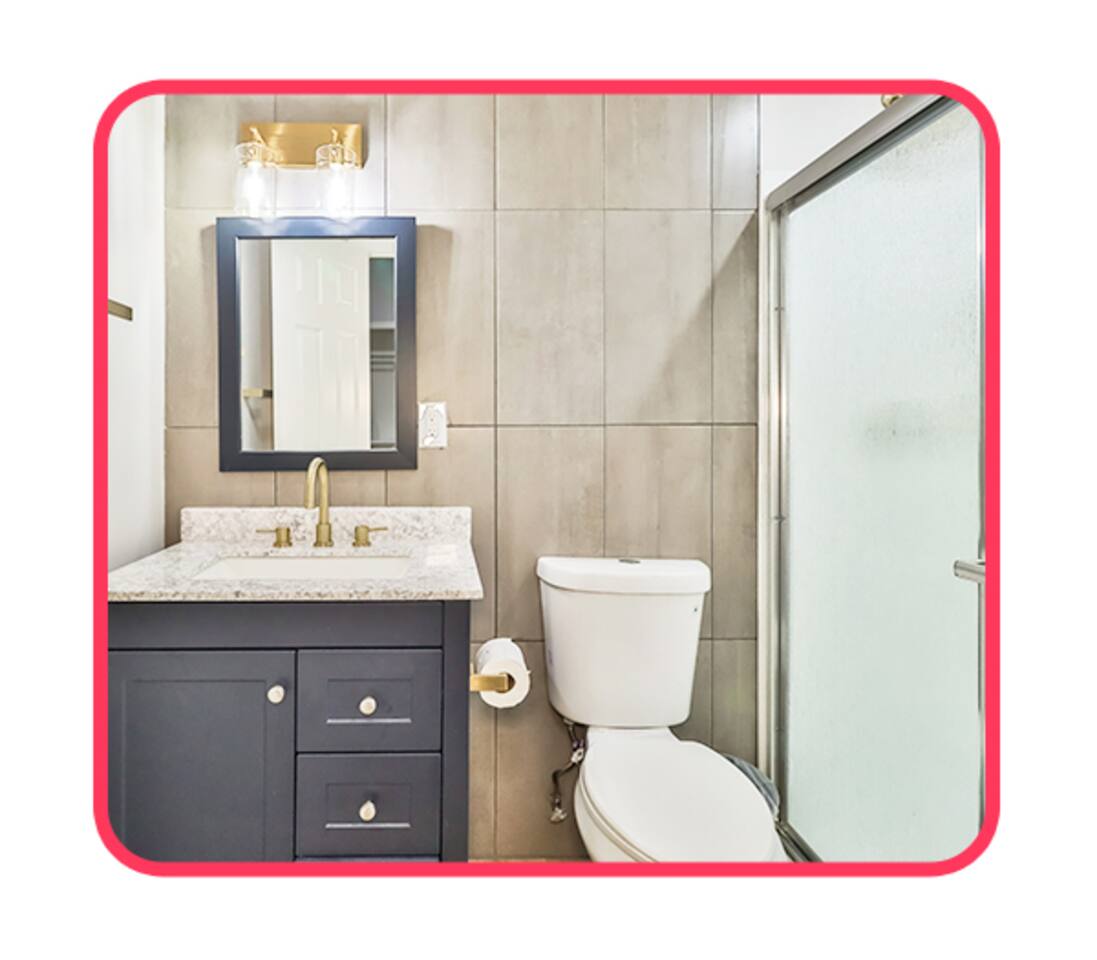 Modern bathroom with brass fixtures and granite vanity.