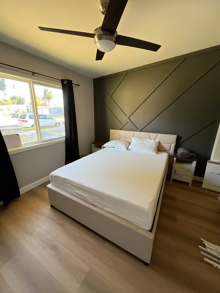 Versatile bedroom layouts featuring a built-in floating desk, comfortable bedding, large windows with dark privacy curtains, and stylish accent walls.