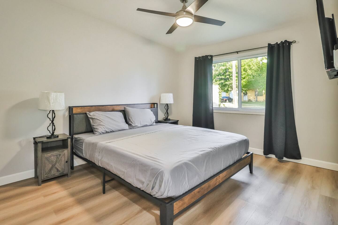 Versatile bedroom layouts featuring a built-in floating desk, comfortable bedding, large windows with dark privacy curtains, and stylish accent walls.