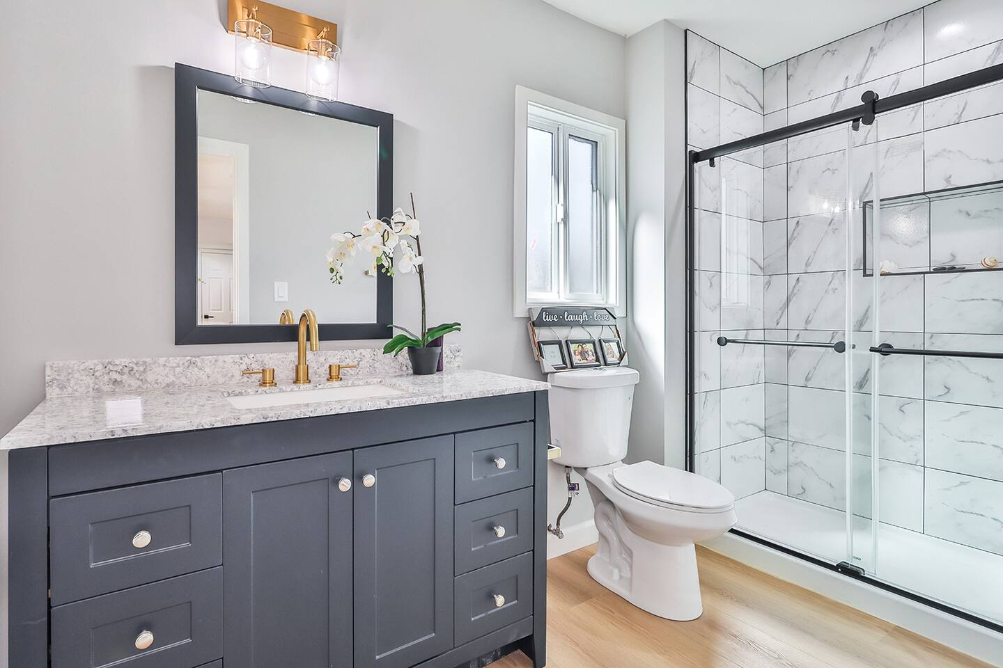 WALK-IN SHOWER WITH GLASS DOORS, MODERN VANITY WITH GOLD FAUCET