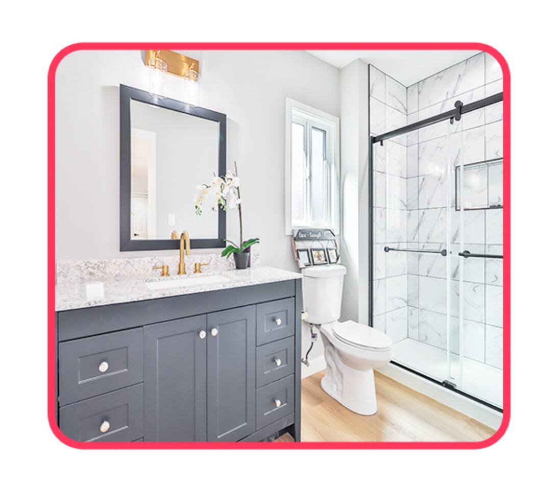 Bright Bathroom with Marble Shower, Gold Fixtures & Orchid Accents – A Spa-Like Escape
