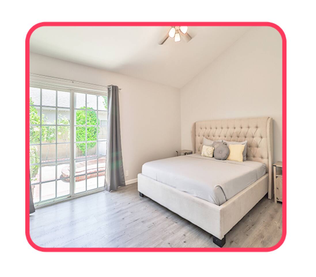 Bright bedroom with patio access and tufted headboard.