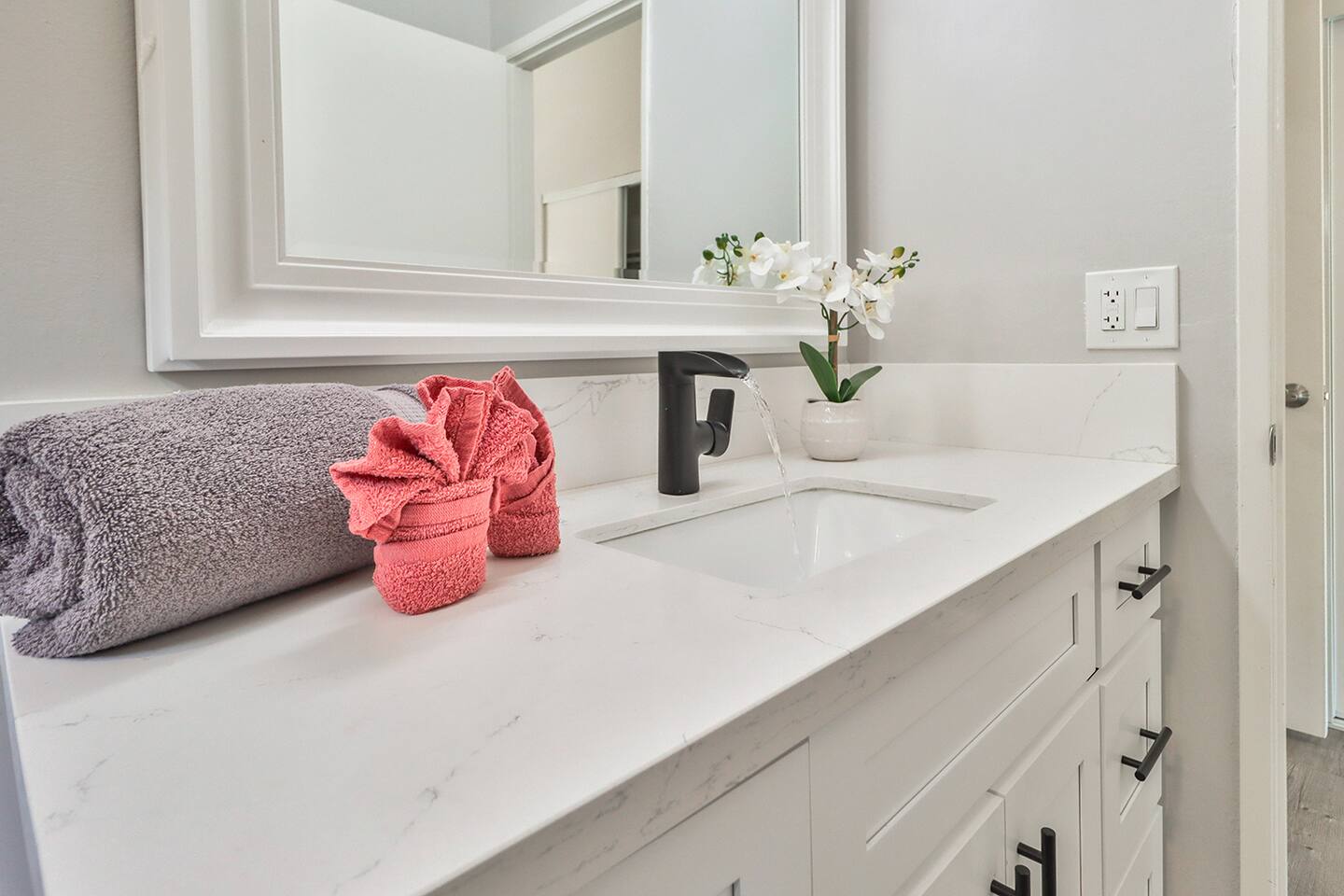 a rectangular sink, a modern black faucet.