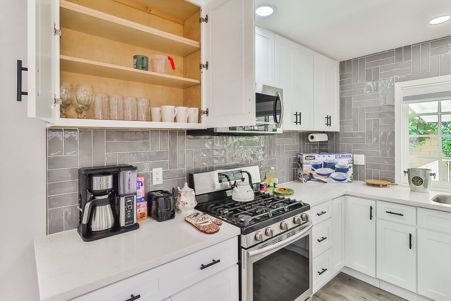 stainless steel appliances, and open shelving displaying glassware.