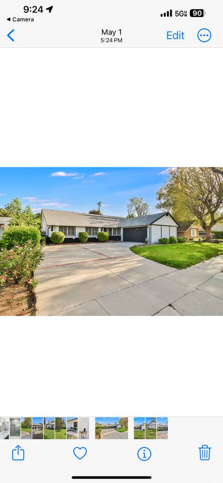 modern ranch-style home with a crisp white and black facade, a large two-car garage, and a manicured lawn with a spacious concrete driveway.