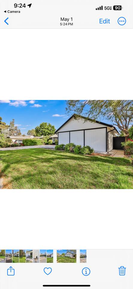 modern ranch-style home with a crisp white and black facade, a large two-car garage, and a manicured lawn with a spacious concrete driveway.