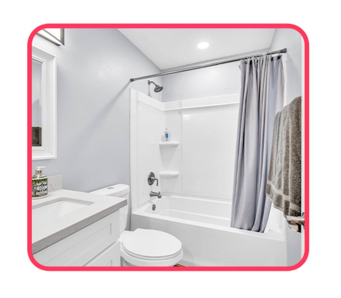 Bright, modern bathroom with full tub and vanity.