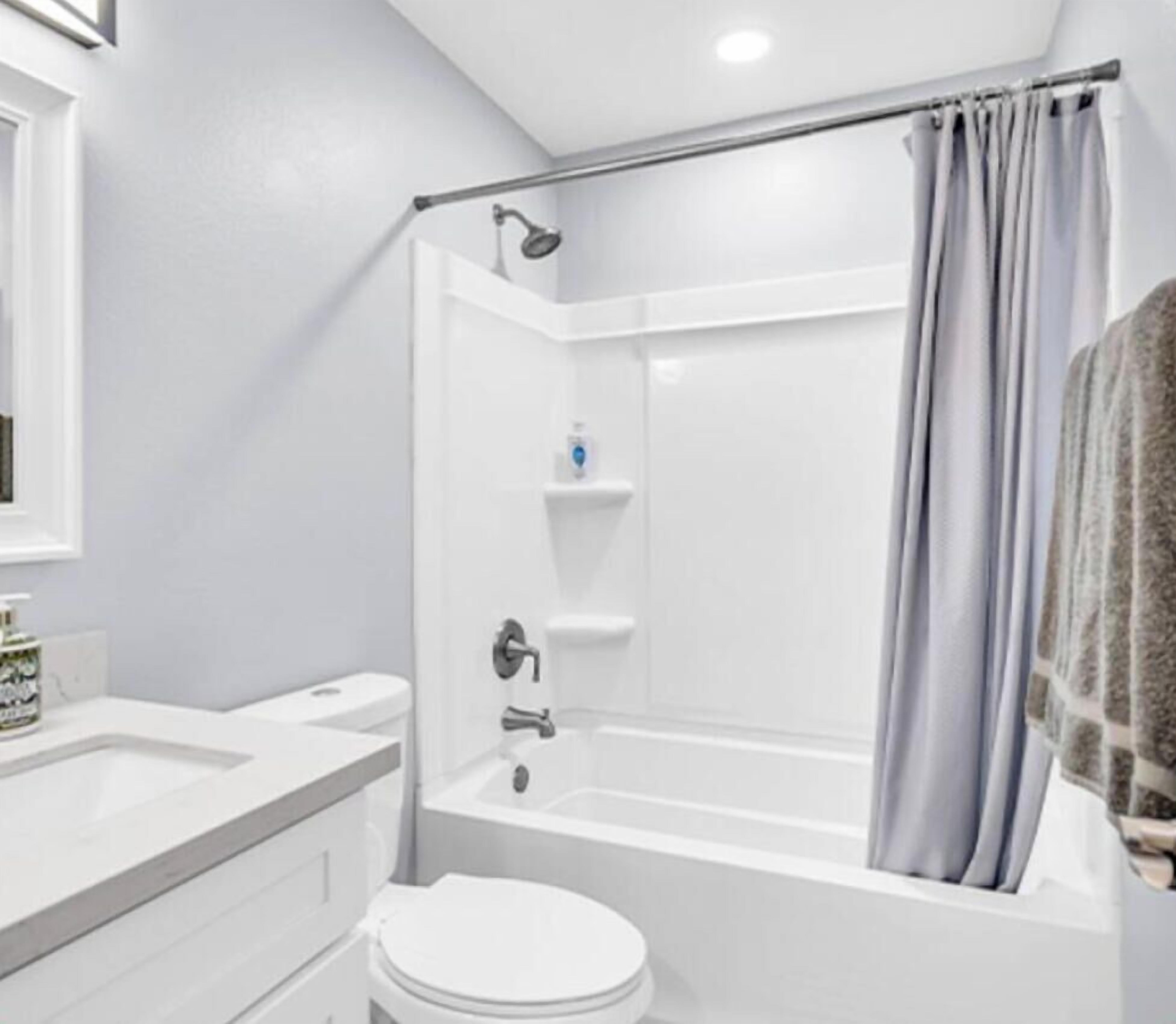 Bright, modern bathroom with full tub and vanity.
