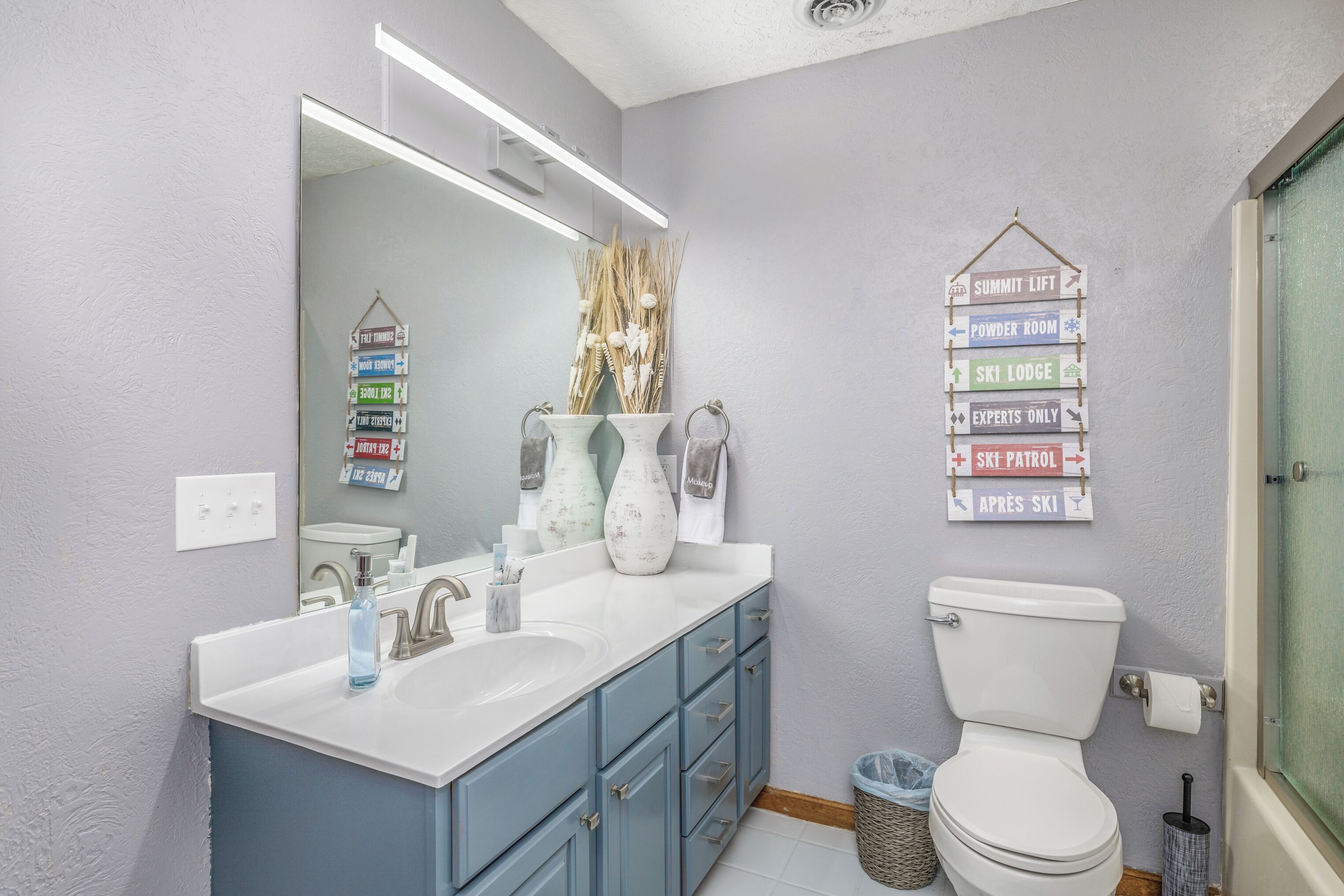 Bright full bathroom with plenty of vanity space and fun ski lodge décor.