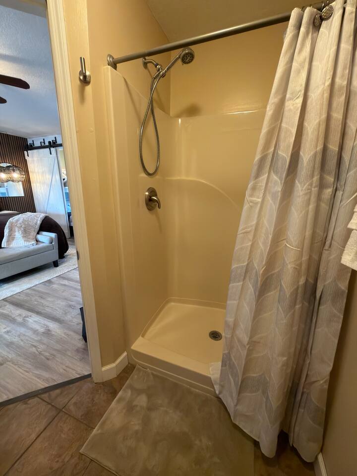 Enjoy the convenience of a private walk-in shower with a handheld showerhead, located just steps from the spacious bedroom suite—perfect for refreshing after a day of exploring the Smoky Mountains.