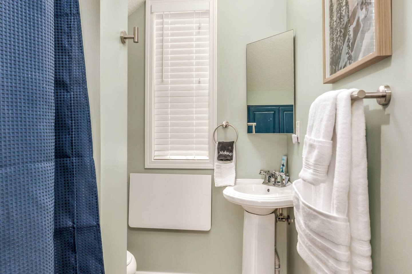 The elegant full bath features a spacious walk-in shower and a thoughtfully designed vanity with a pop-up counter extension, providing added convenience and extra space for your daily routine.