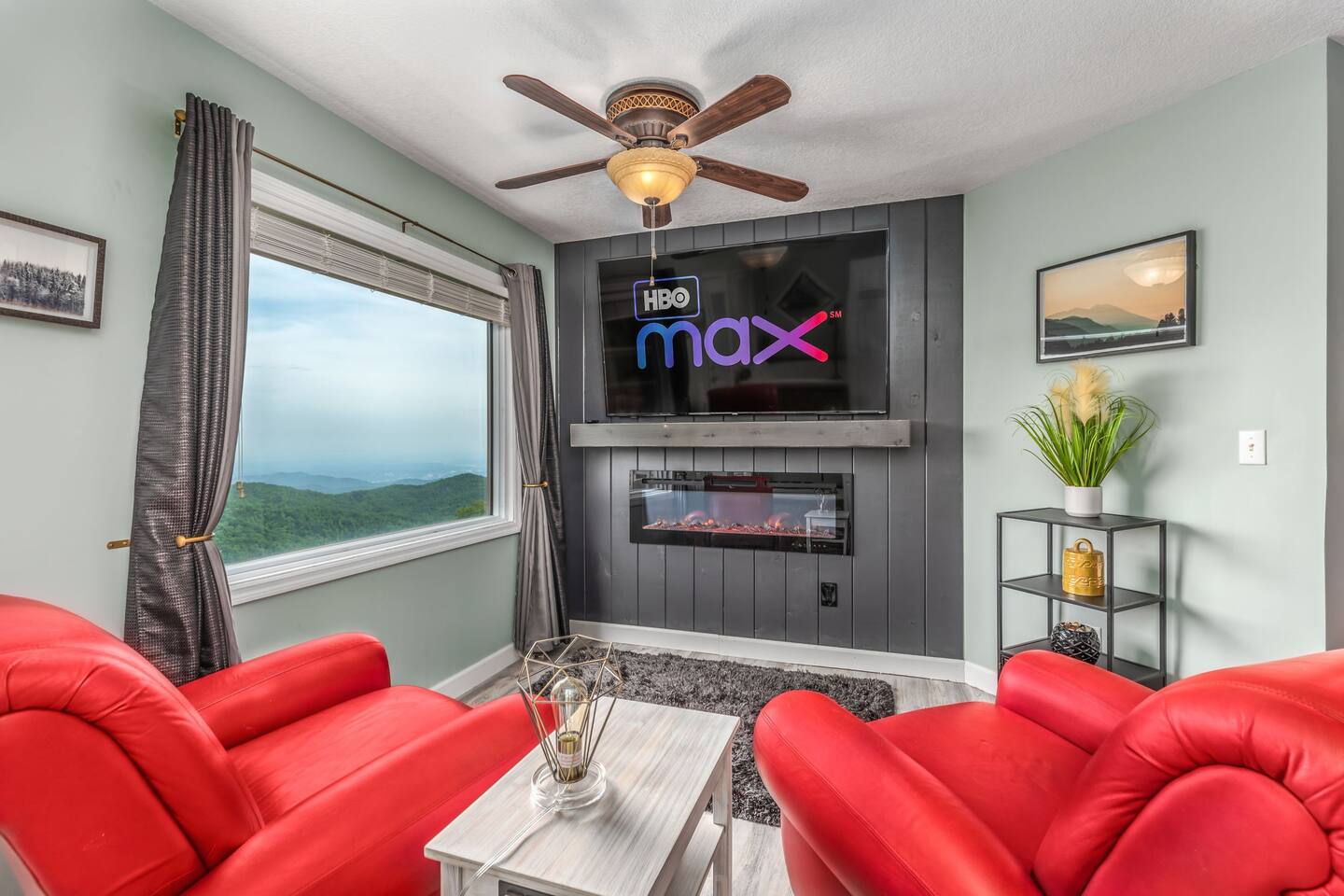 Relax in the private master suite sitting area, featuring a 70" 4K Smart TV, a cozy electric fireplace, and breathtaking panoramic mountain views that are even more spectacular in person.