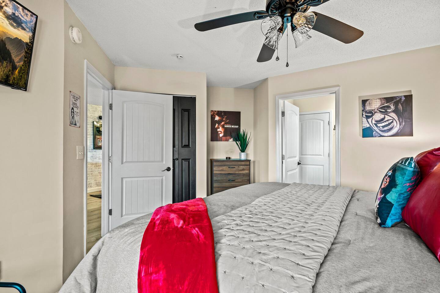 A spacious and comfortable bedroom designed for relaxing after a day of family fun in the Smokies. Enjoy cozy bedding, playful music-inspired décor, a Smart TV, and convenient access to the adjoining bath.