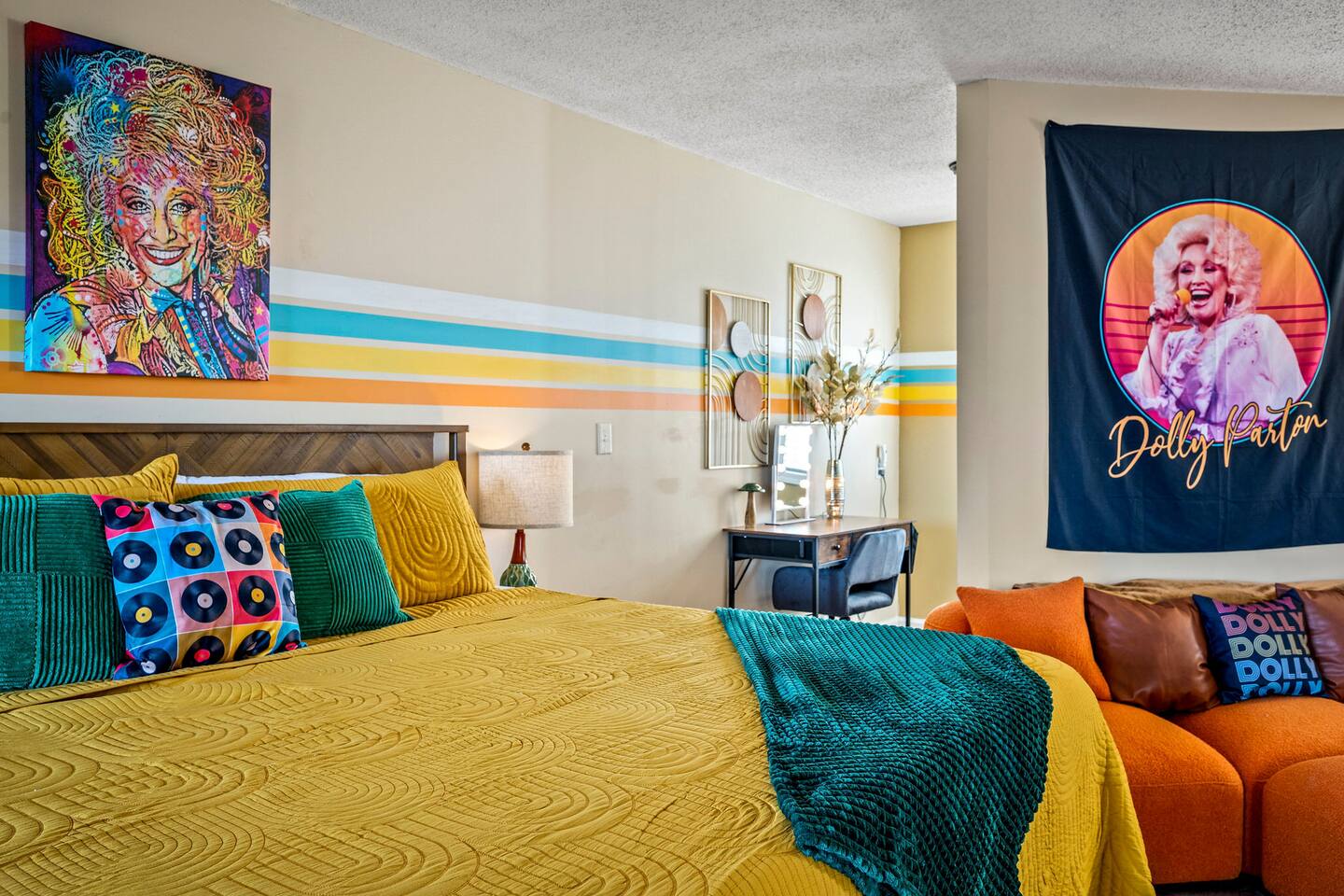 A colorful, music-inspired retreat with cozy bedding, a comfy sitting area, and a dedicated vanity or workspace. Fun Dolly Parton touches add a little Smoky Mountain charm to this spacious room the whole family will enjoy!