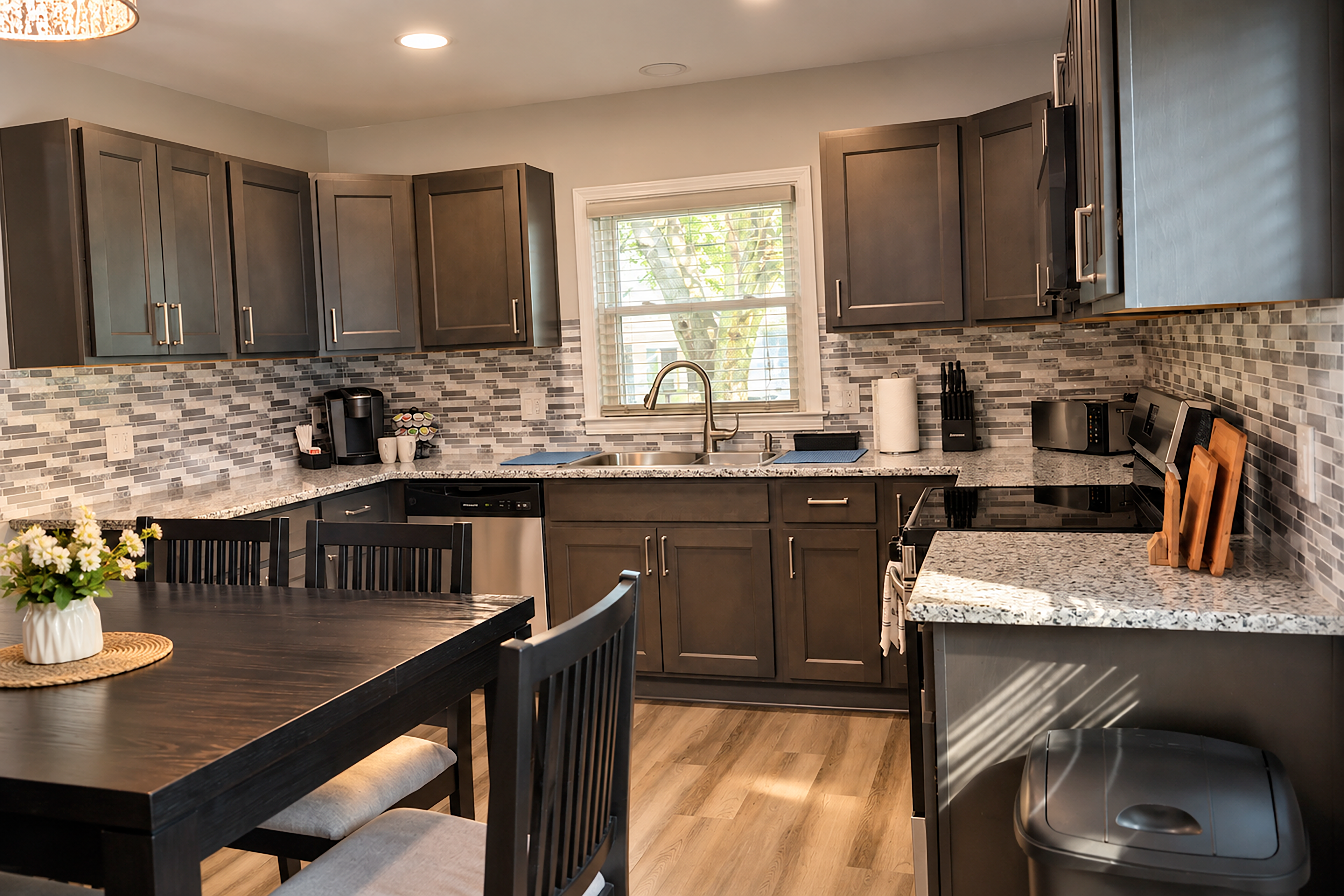 Modern kitchen with granite counters, dining space, and bright window