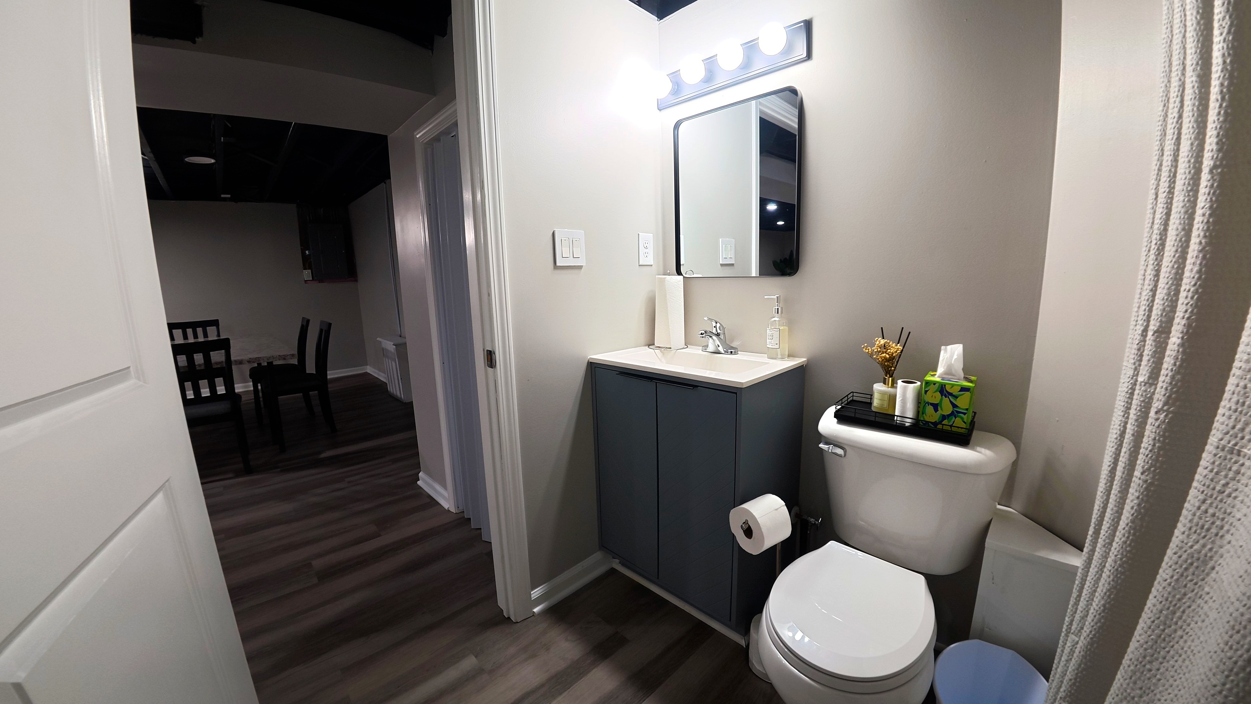 Modern guest bathroom with bright vanity lighting and updated finishes