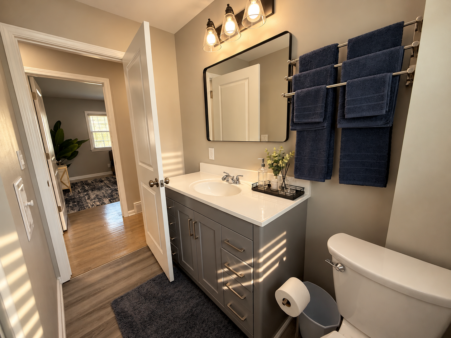 Bright modern bathroom with stylish vanity, warm lighting, and plush towels