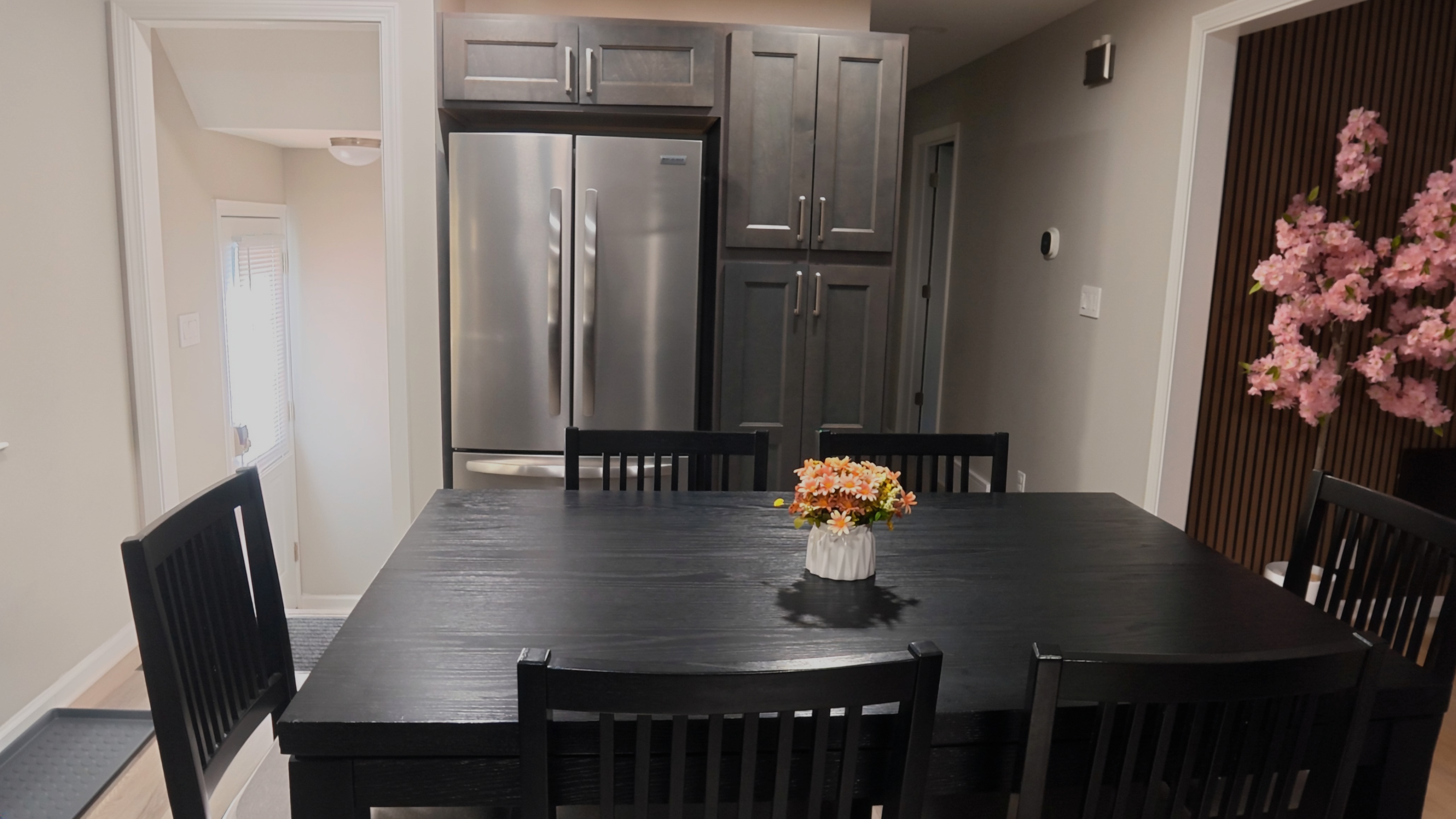 Modern dining area with seating for 6 beside a sleek, upscale kitchen