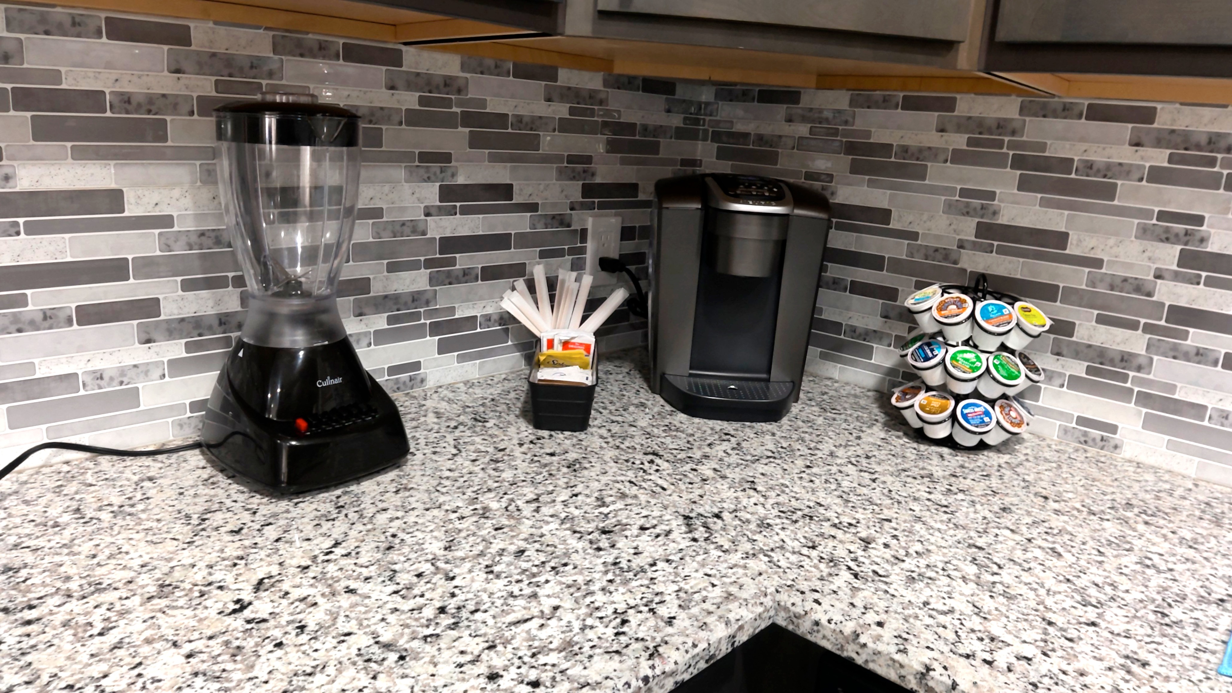 Modern kitchen coffee station with granite counters and blender