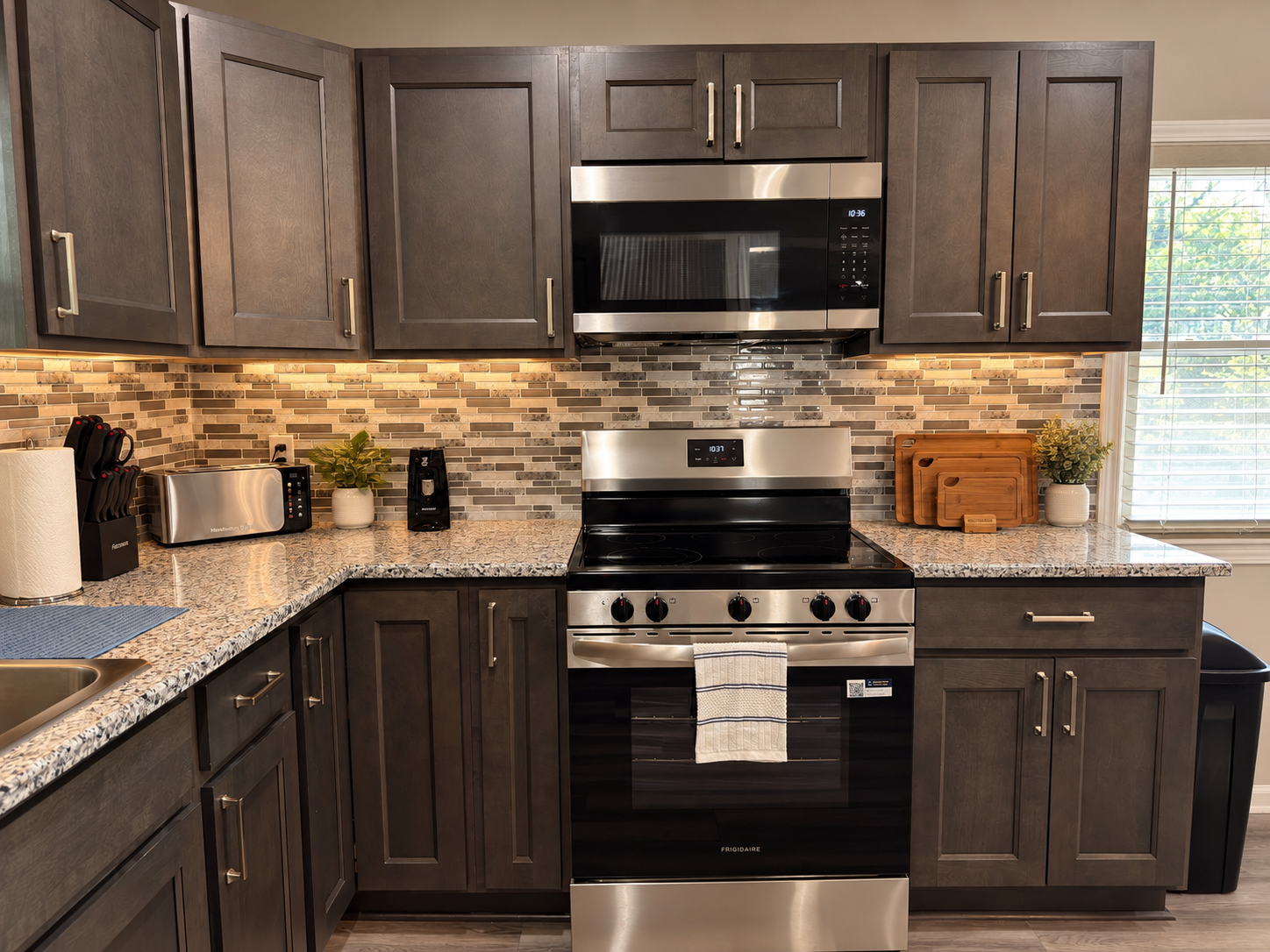 Modern kitchen with granite counters, stainless appliances, and warm lighting