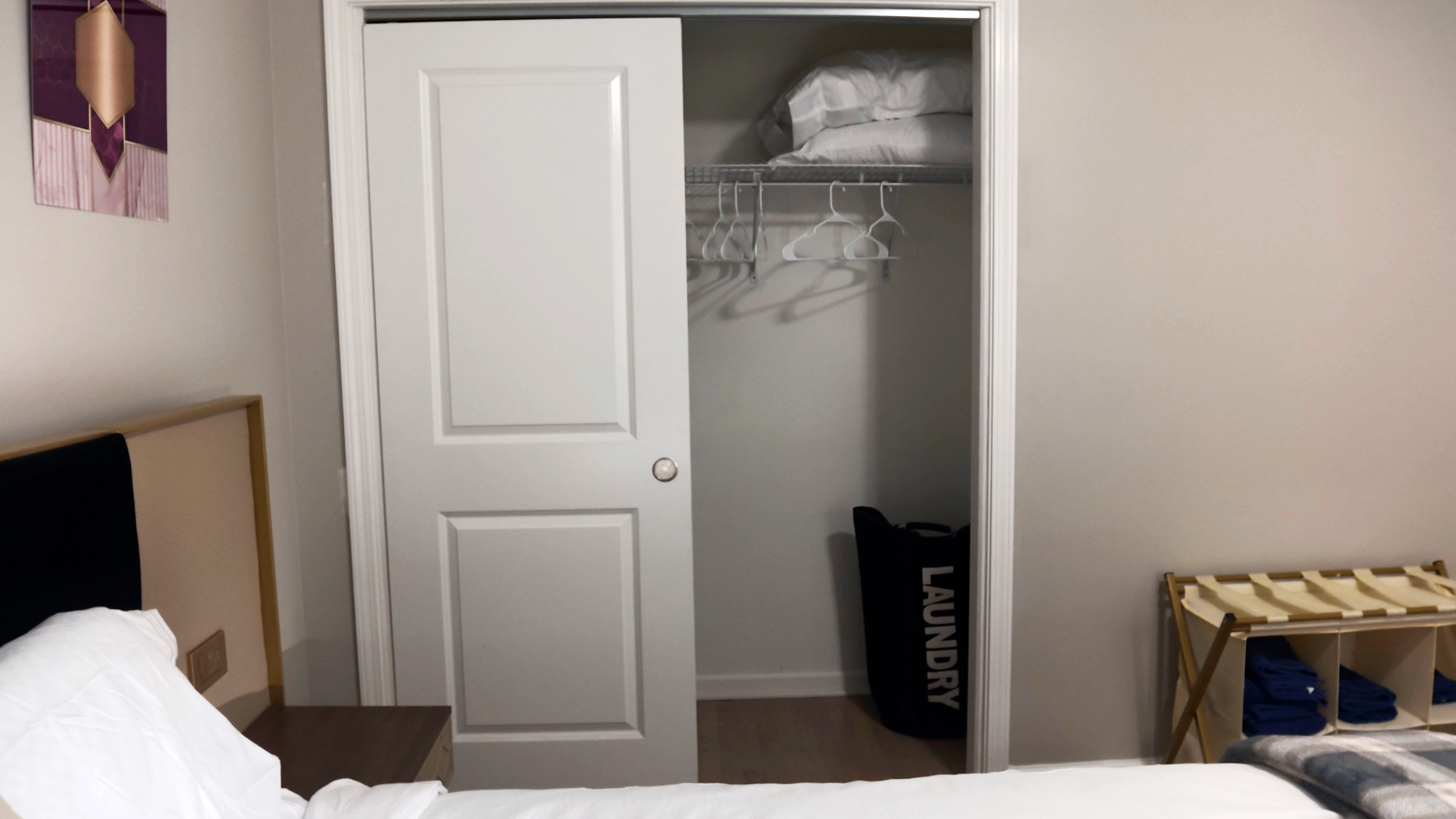 Bedroom with closet storage, luggage rack, and thoughtful guest amenities