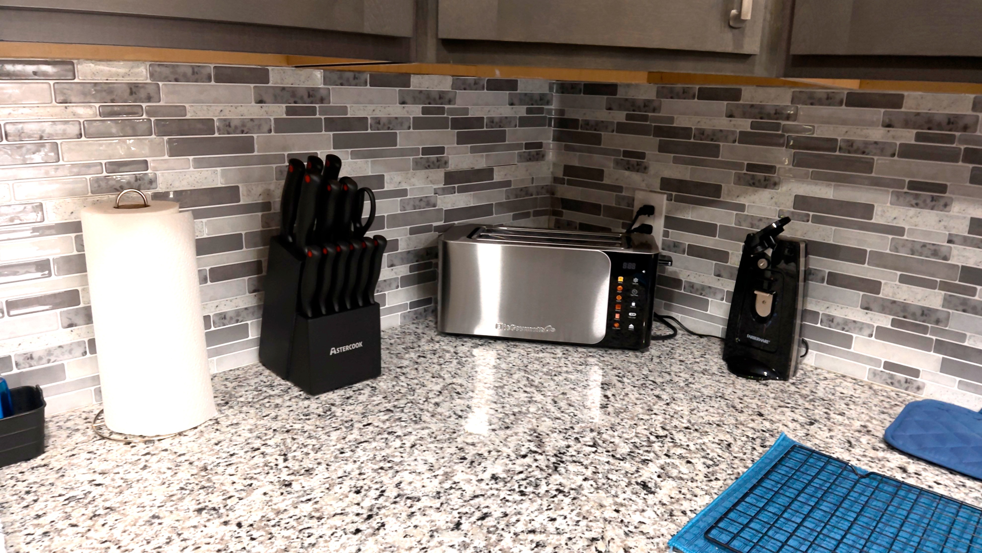 Modern granite kitchen counter with coffee maker and sleek tile backsplash