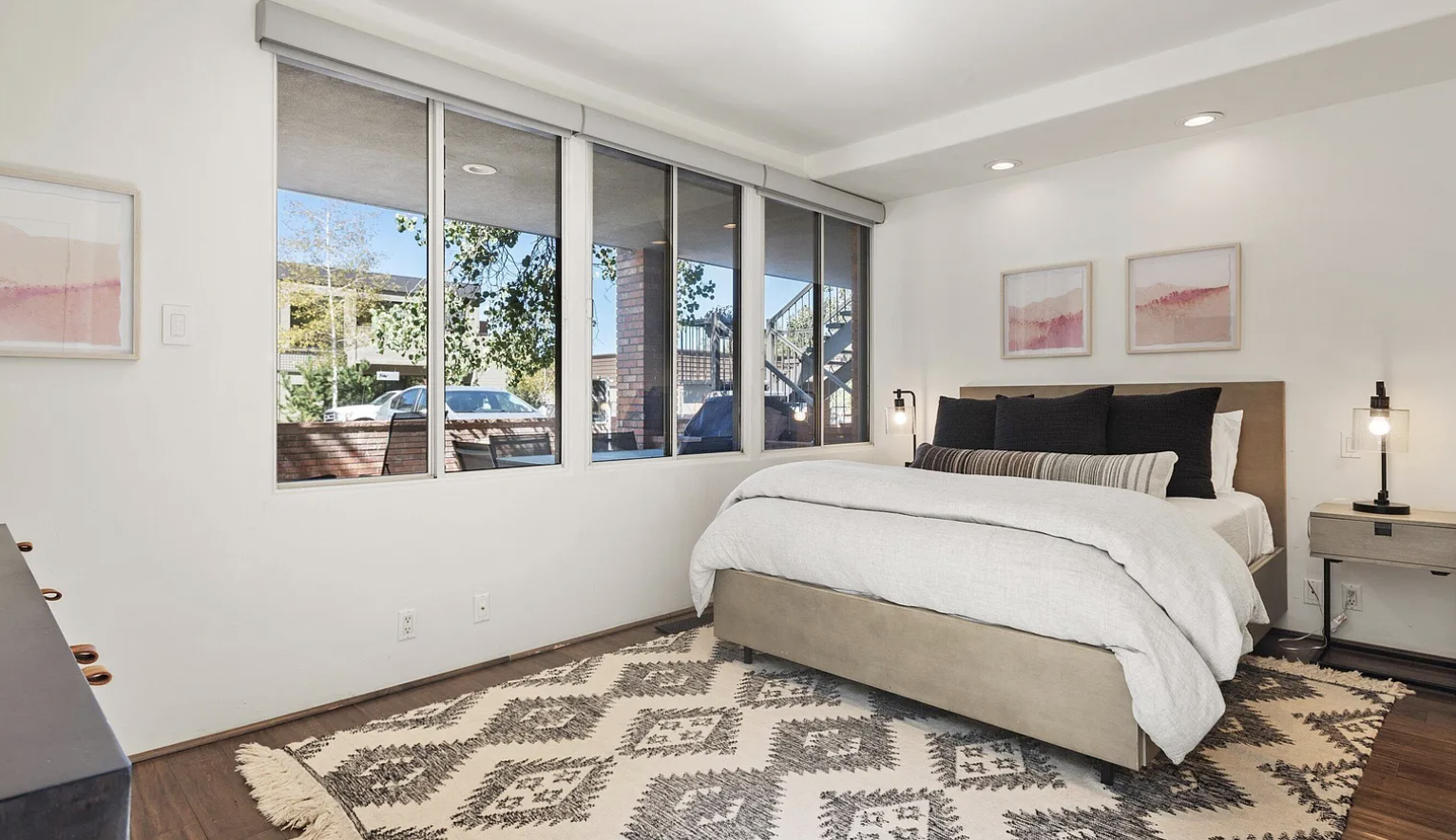 Bright modern bedroom with large windows and stylish, cozy design