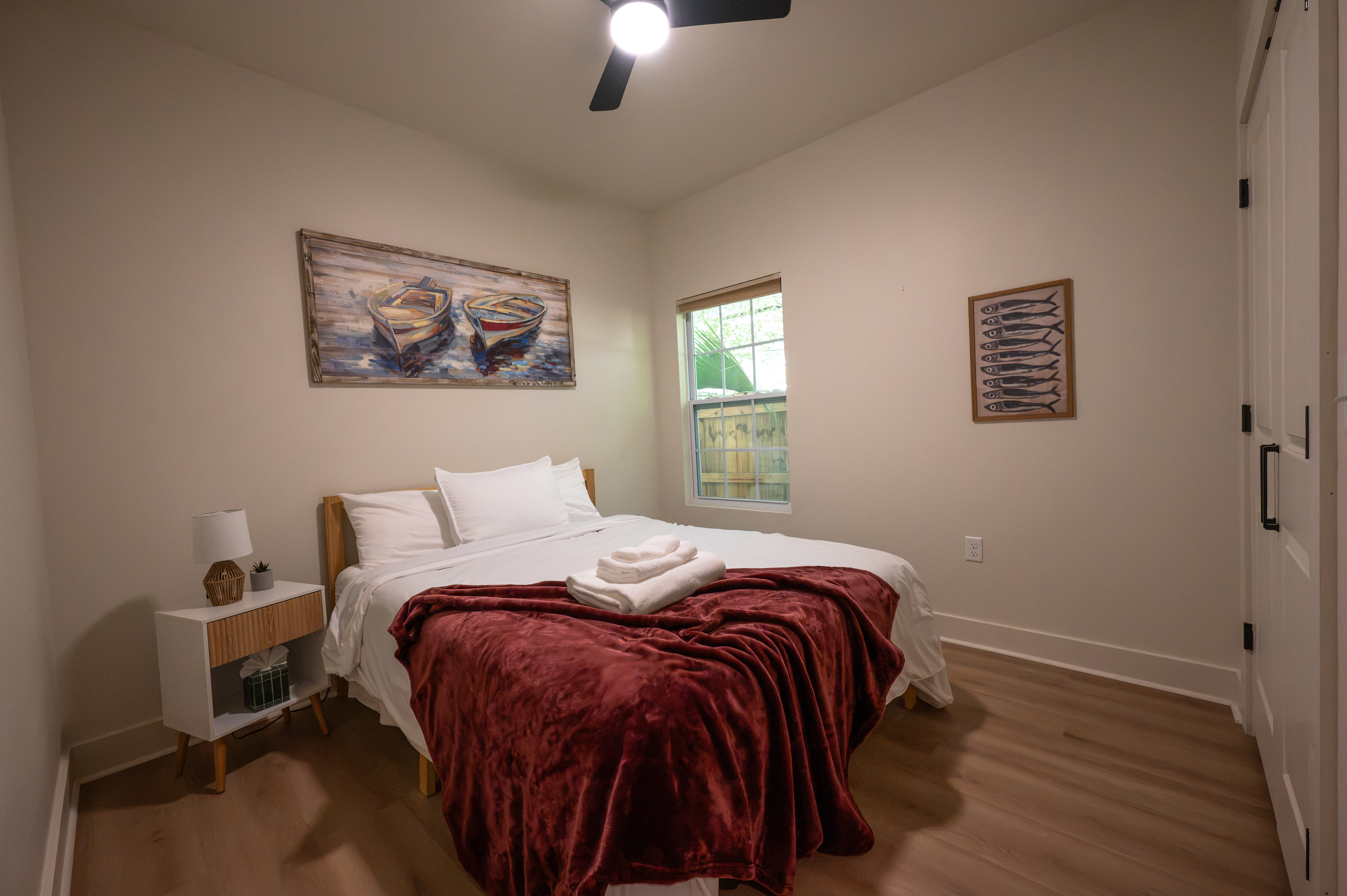 Cozy bedroom with plush linens, natural light, and charming coastal decor