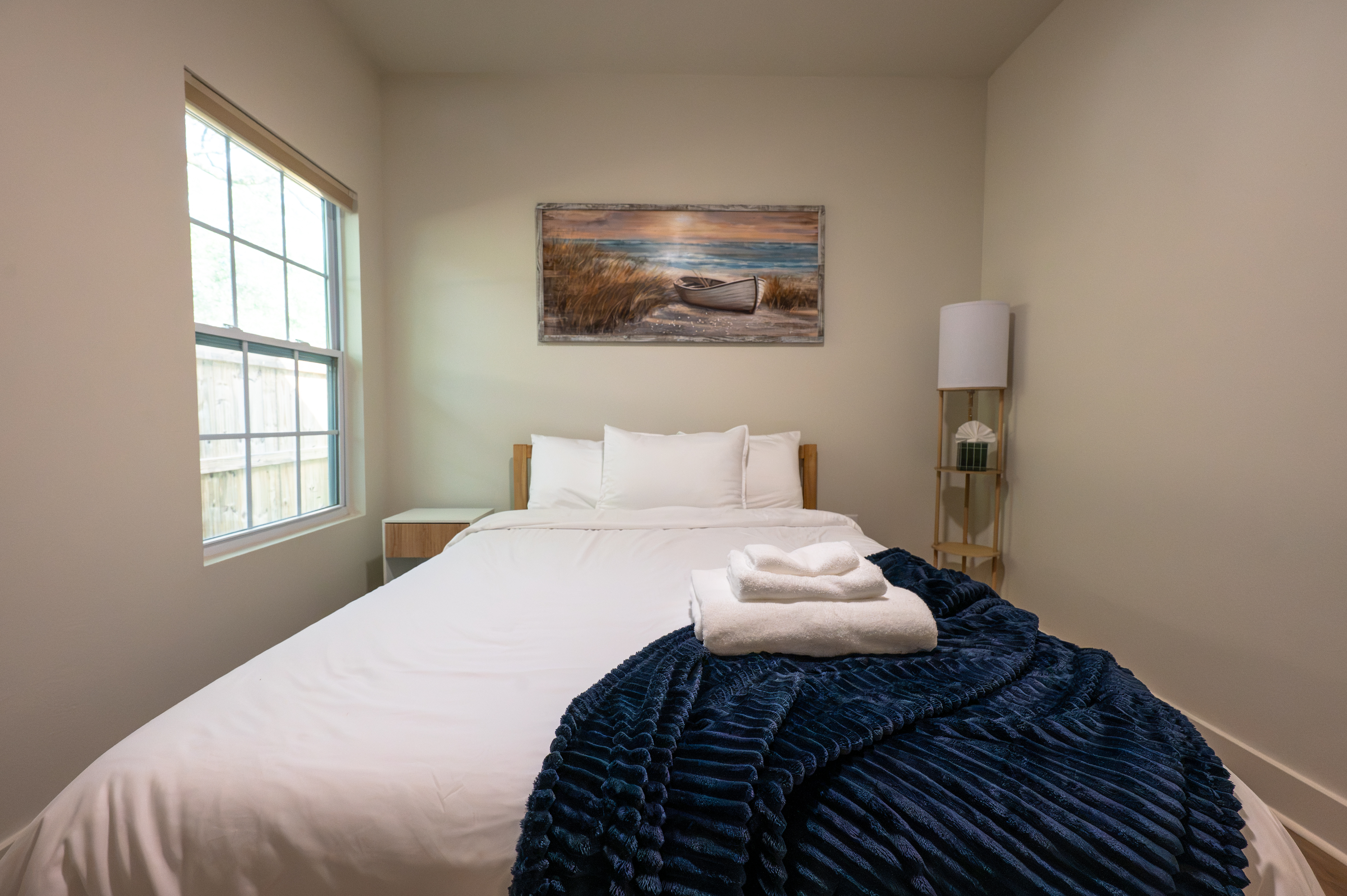 Bright, cozy bedroom with crisp linens and calming coastal decor