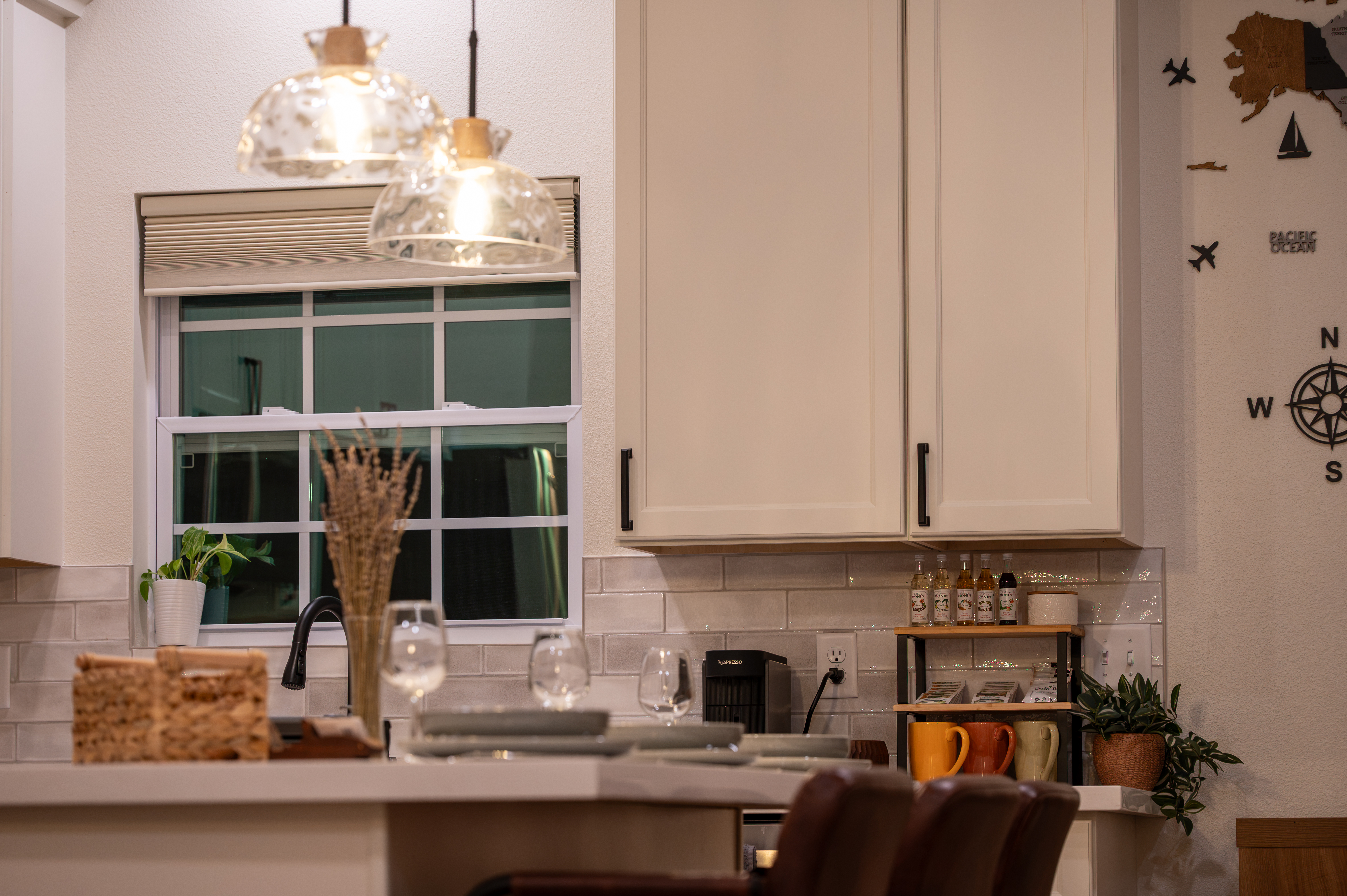 Modern kitchen with pendant lighting, bar seating, and warm designer touches