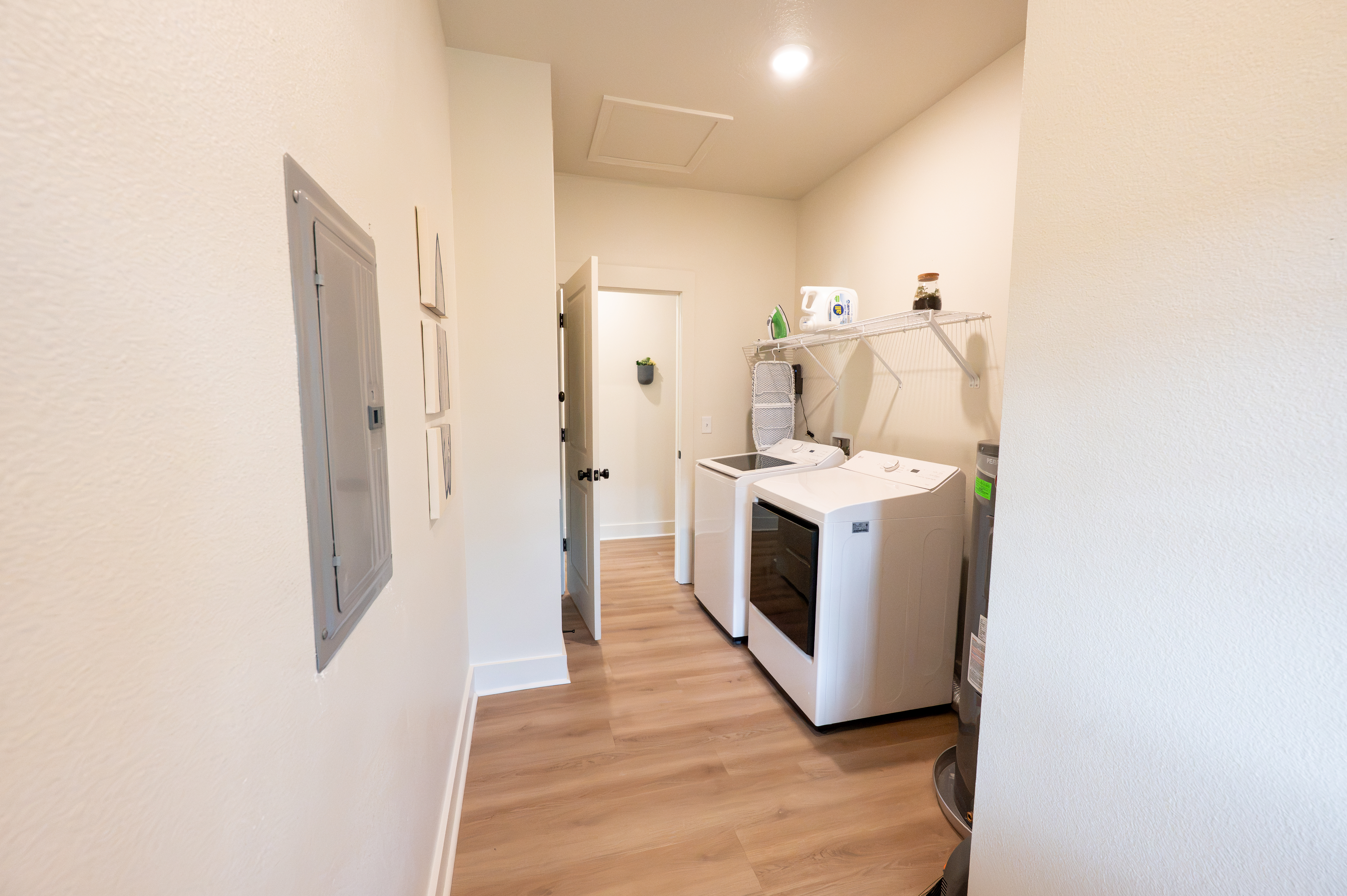 Bright in-home laundry room with full-size washer, dryer, and storage
