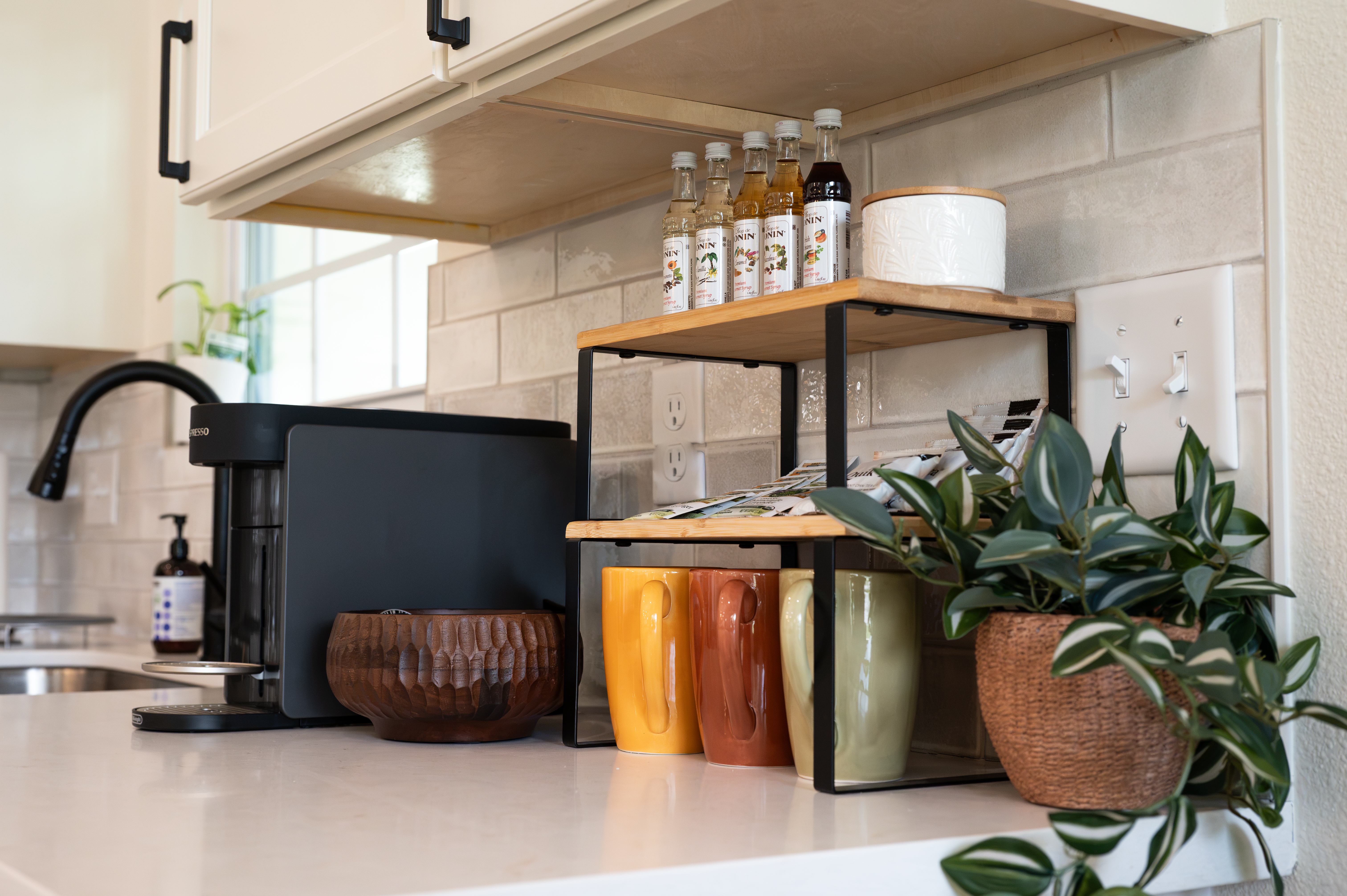 Cozy coffee station with stocked syrups, mugs, and stylish kitchen details