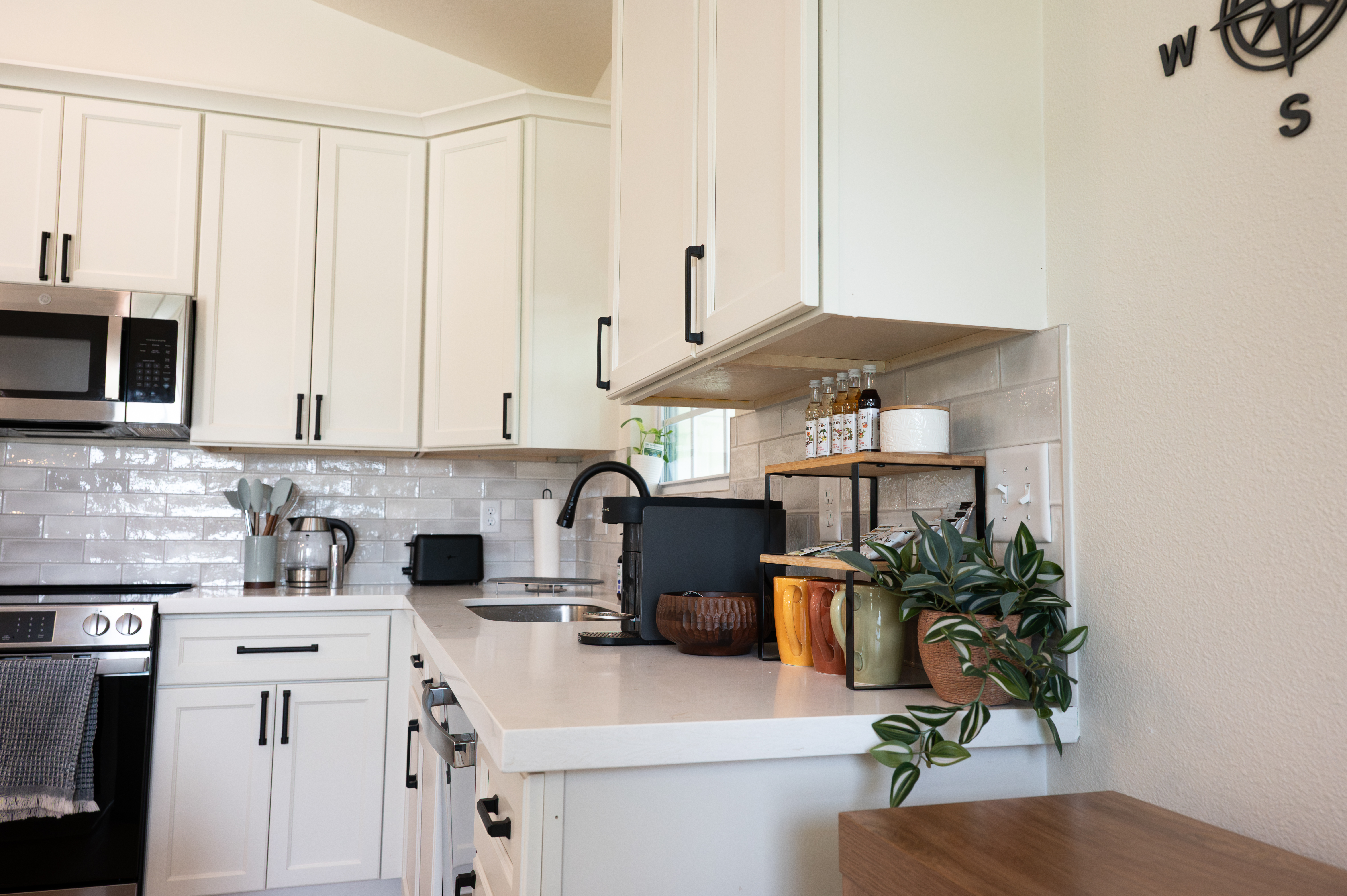 Bright modern kitchen with white cabinets, sleek finishes, and stylish decor