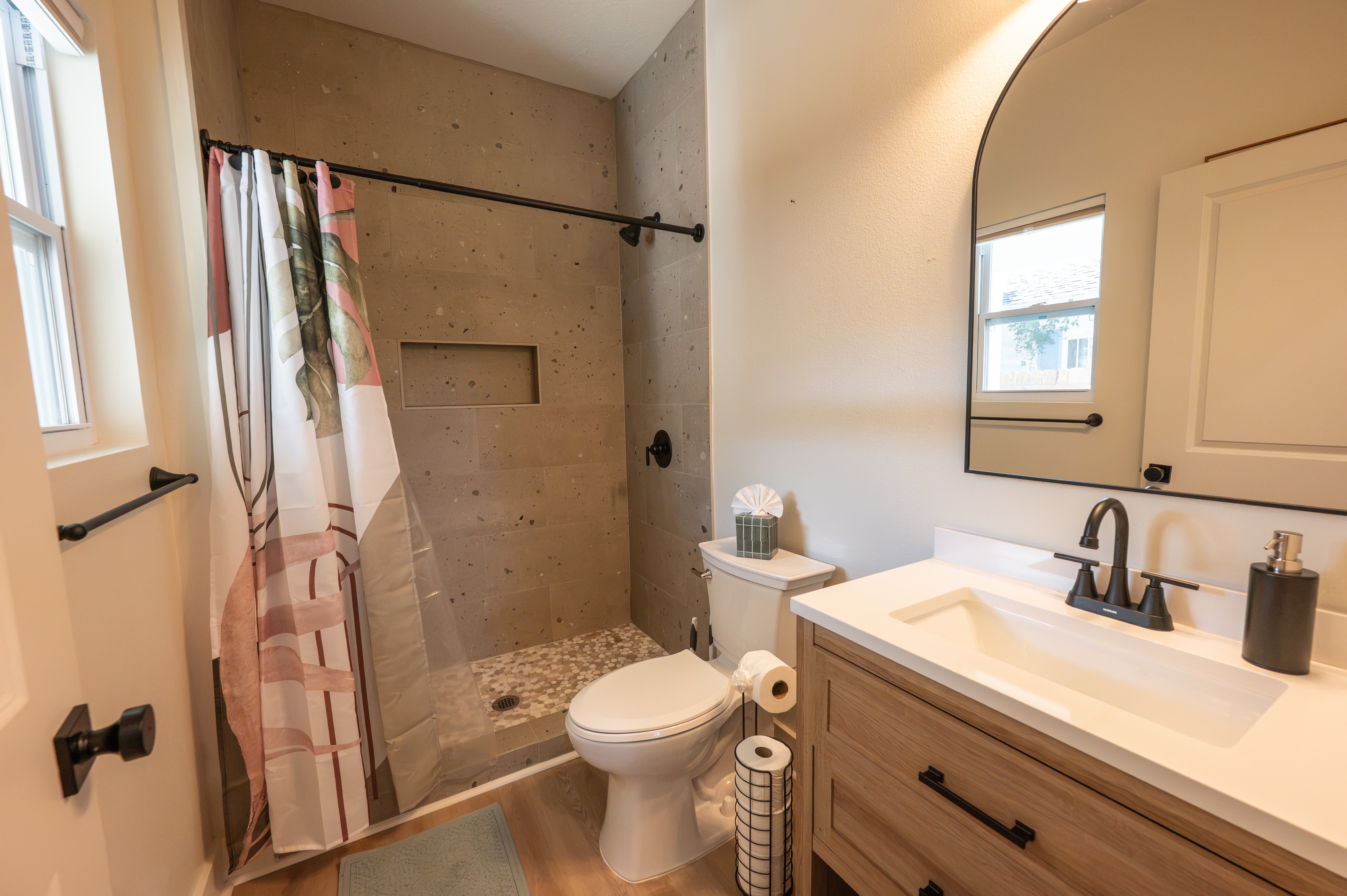 Bright modern bath with tiled walk-in shower and stylish vanity