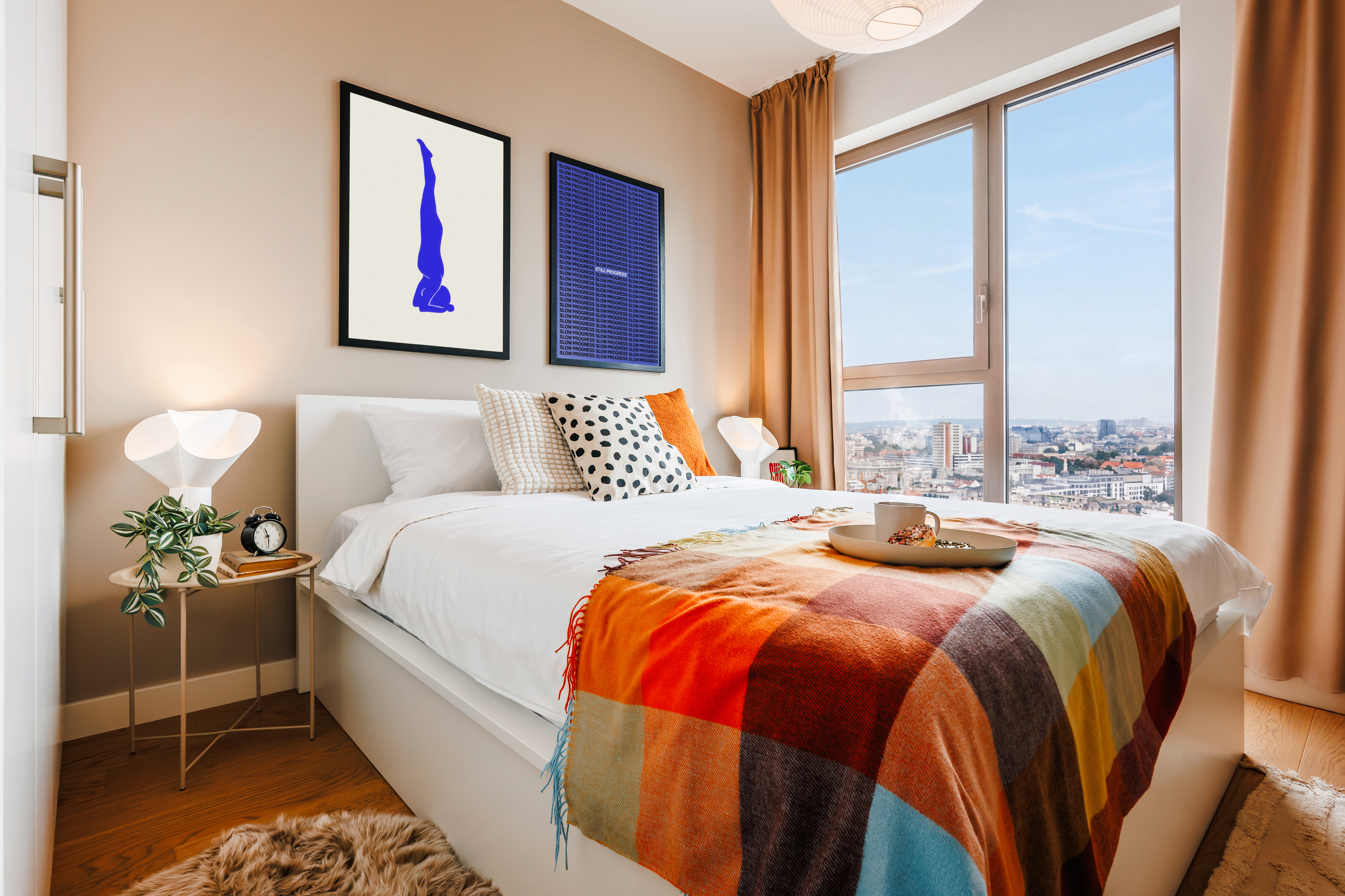 Bright modern bedroom with city views and a cozy designer touch