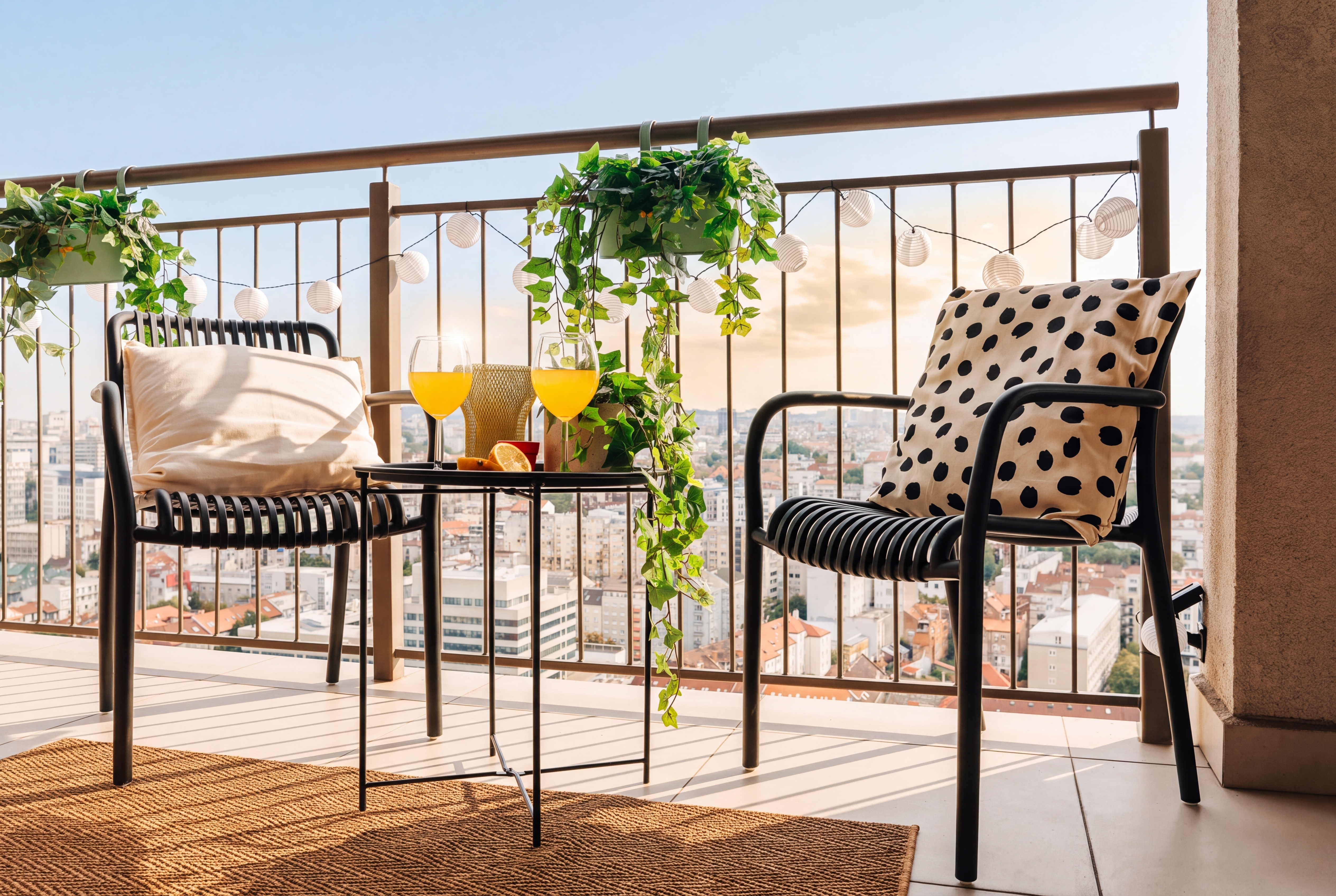 Sunny city-view balcony with stylish seating and a cozy lounge setup