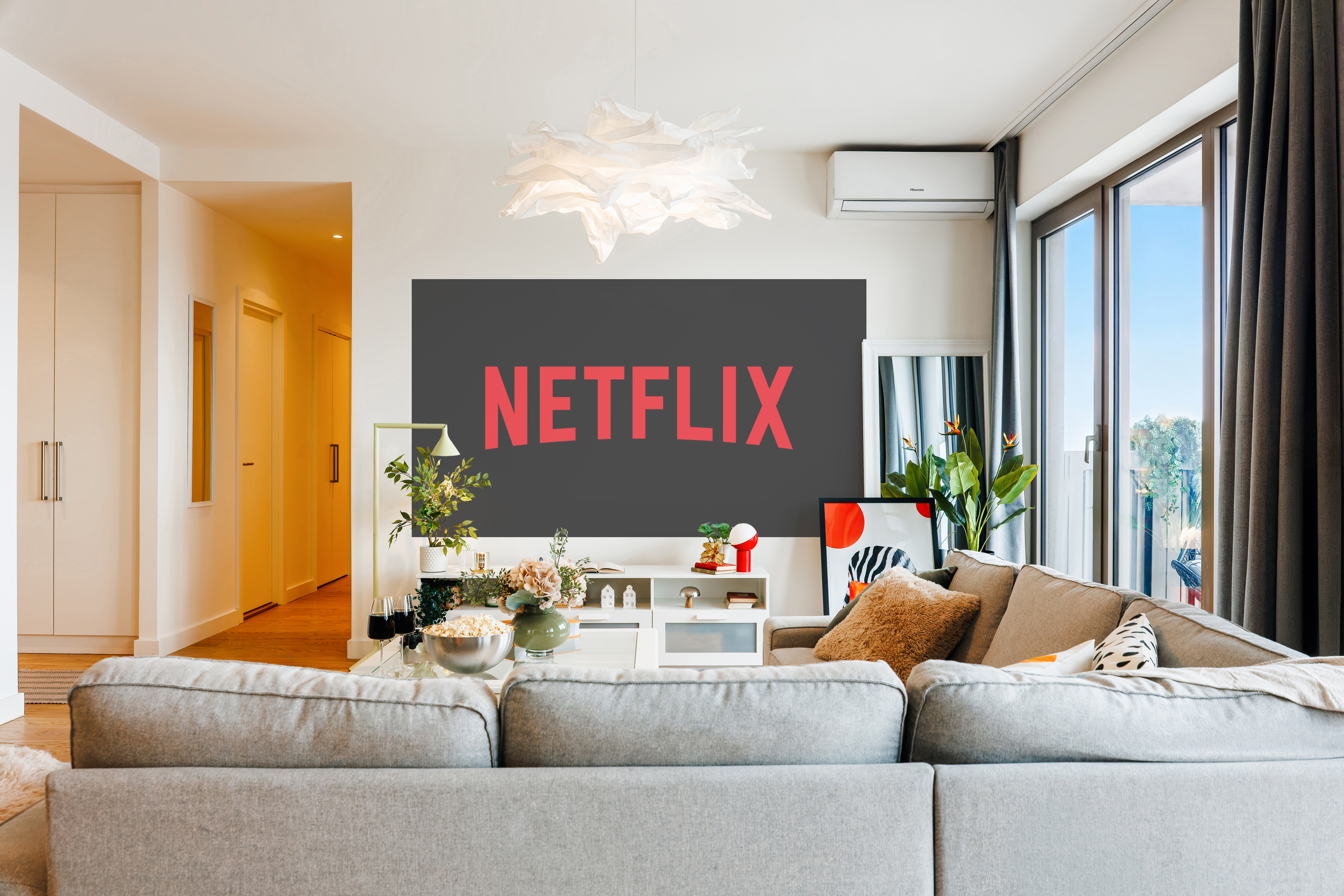 Bright modern lounge with big TV, cozy sectional, and sun-filled windows