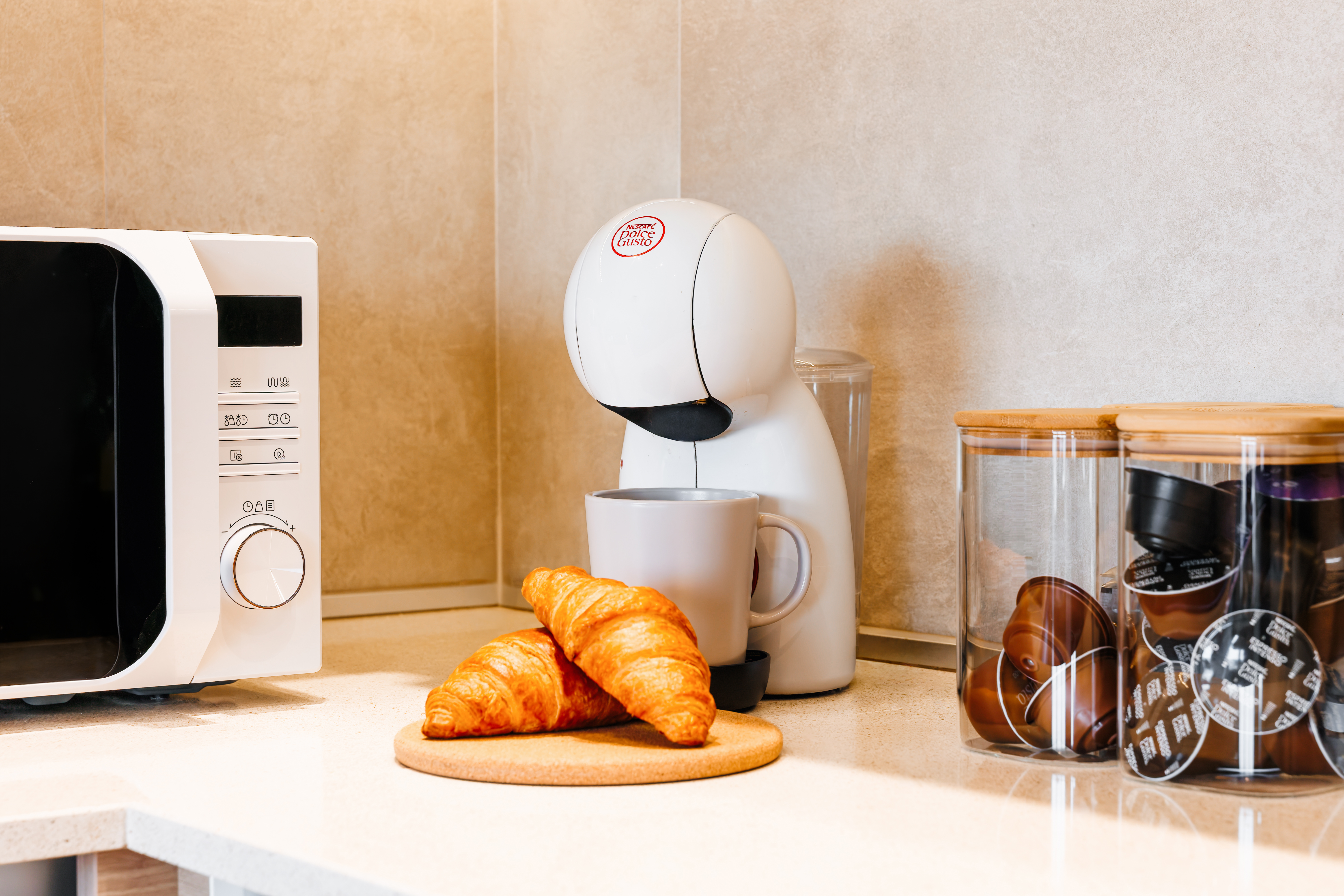 Cozy coffee corner with microwave, pod machine, and fresh breakfast vibes